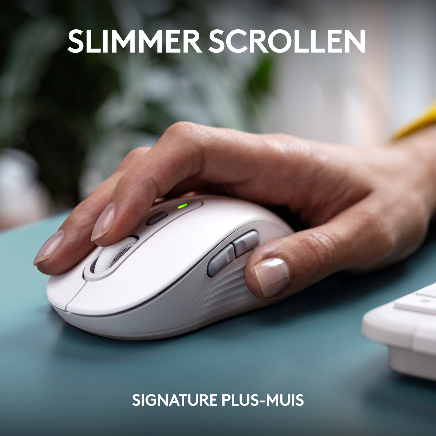 A hand uses a white Logitech mouse on a blue-green surface.