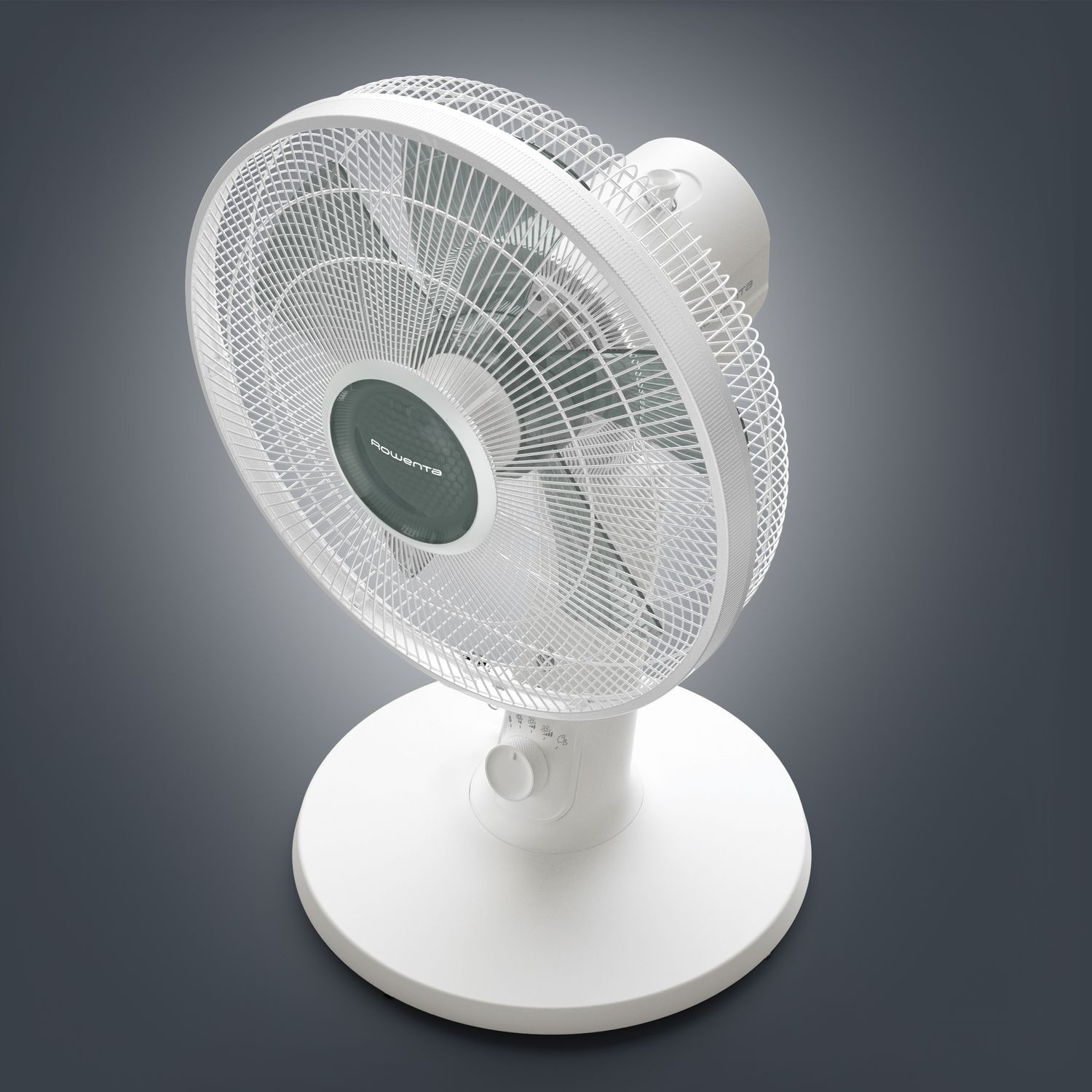 A white fan on a gray surface. The fan has a round design.