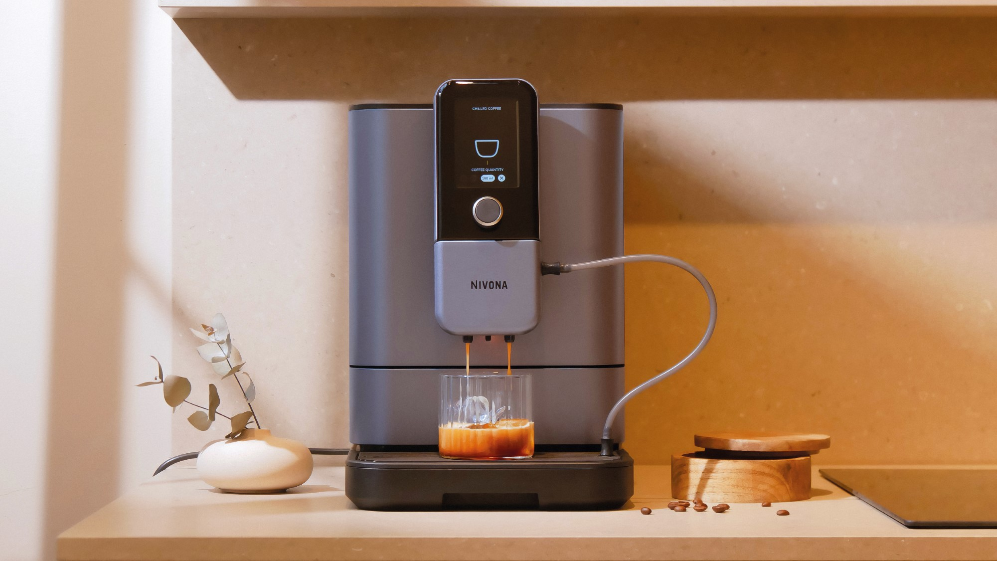 Ekspres do kawy nalewający kawę do szklanki. Kilka ziaren kawy na drewnianej powierzchni.