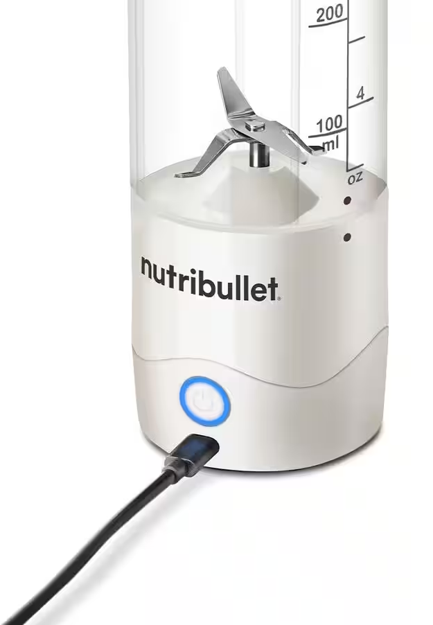 Blender NutriBullet blanc avec lame, câble de charge branché, sur surface blanche.