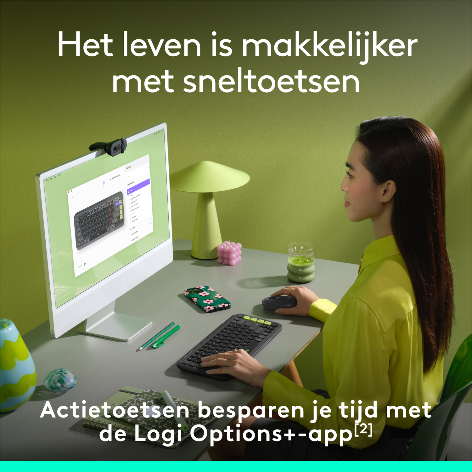 Vrouw zit aan een bureau en gebruikt een toetsenbord en monitor.