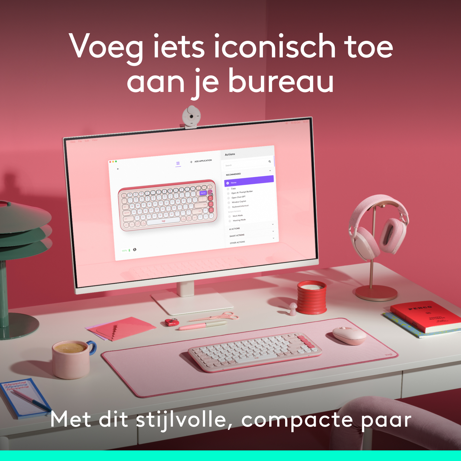 Een bureau-opstelling met een monitor, toetsenbord, muis, koptelefoon en notitieblok in een roze thema.