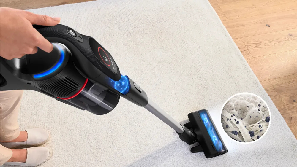 Odkurzacz bezprzewodowy czyszczący biały dywan. Szczegóły brudu w okręgu.