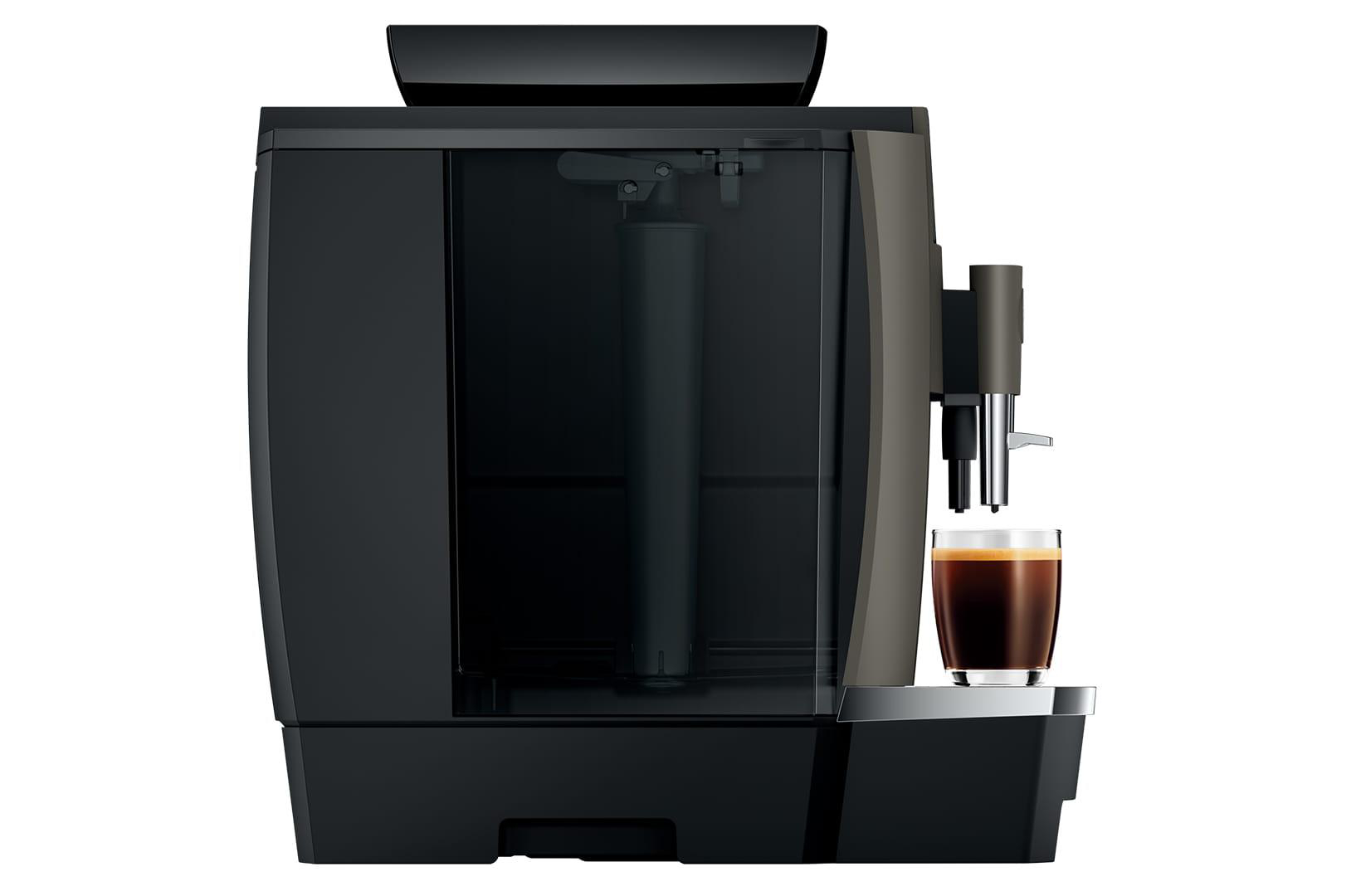 Schwarze Jura Kaffeemaschine mit einem Glas Kaffee, freigestellt auf weißem Hintergrund.