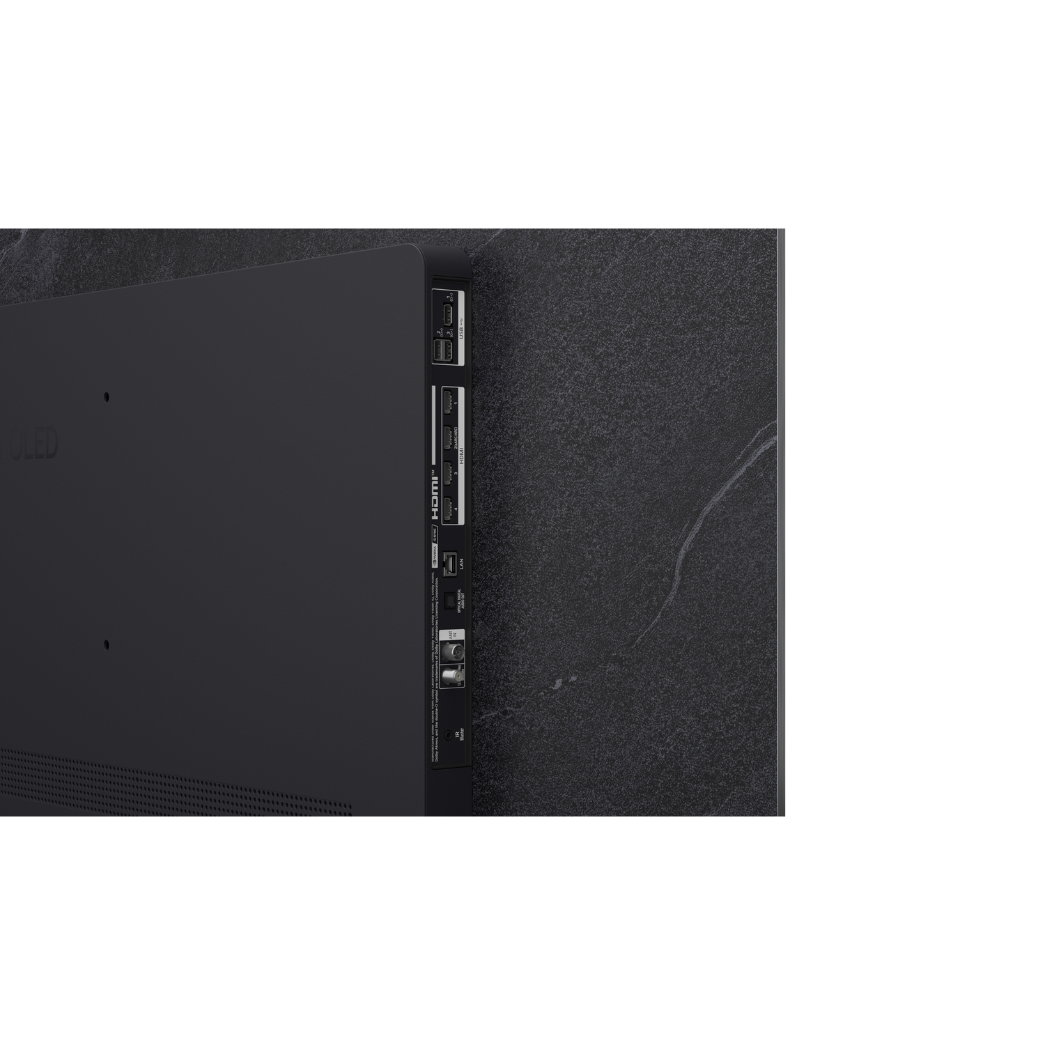 Arrière d'une télévision noire avec ports et connexions. La télévision est sur un mur texturé.