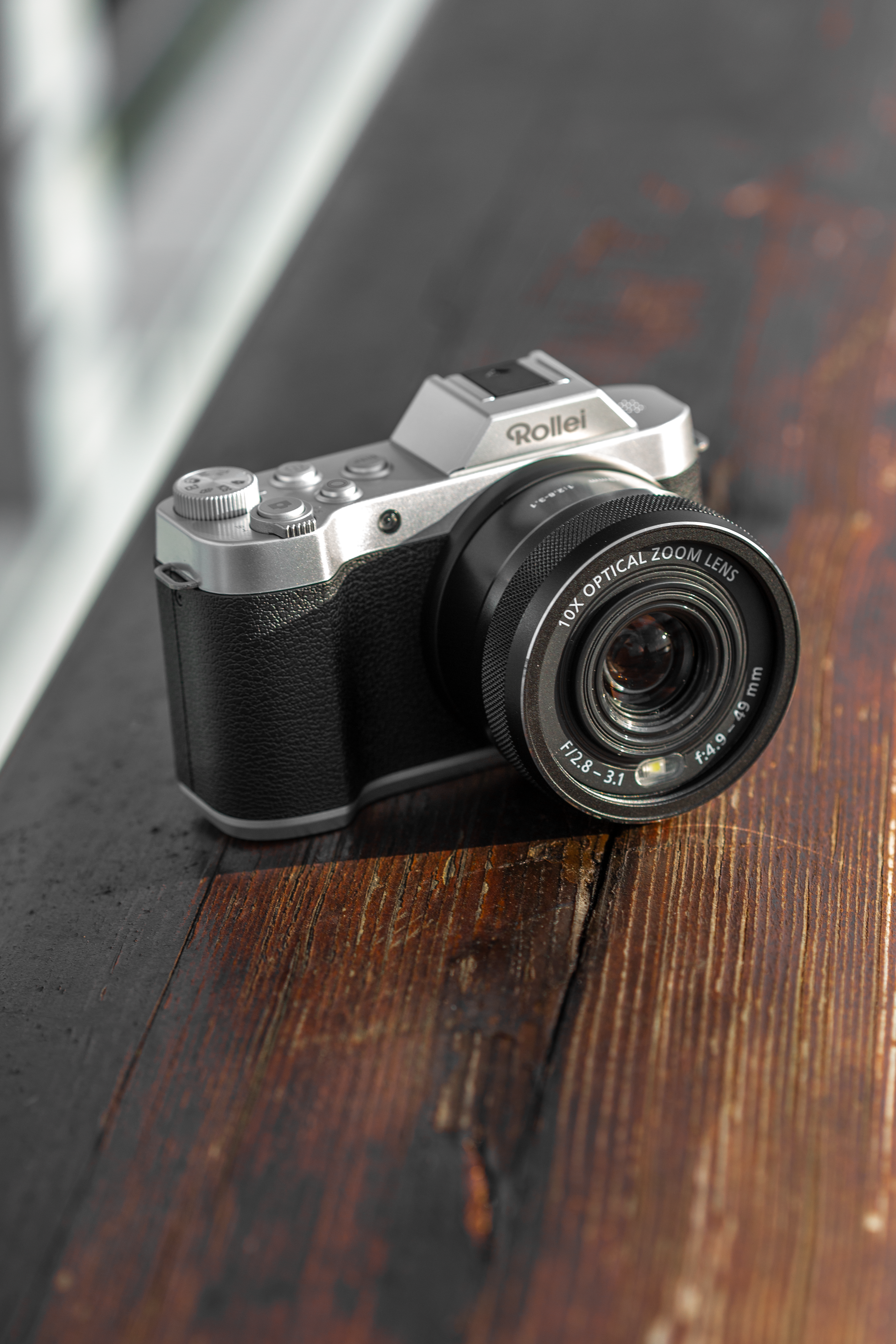 Una fotocamera con un obiettivo su un tavolo di legno.