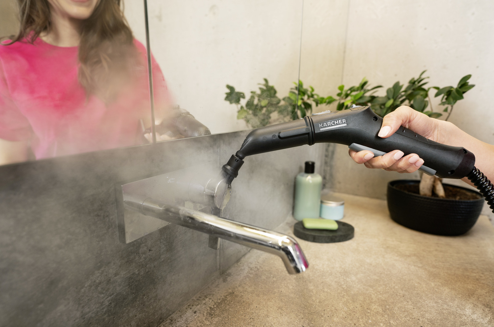 Osoba używa parownicy do kranu w łazience. Para jest widoczna.