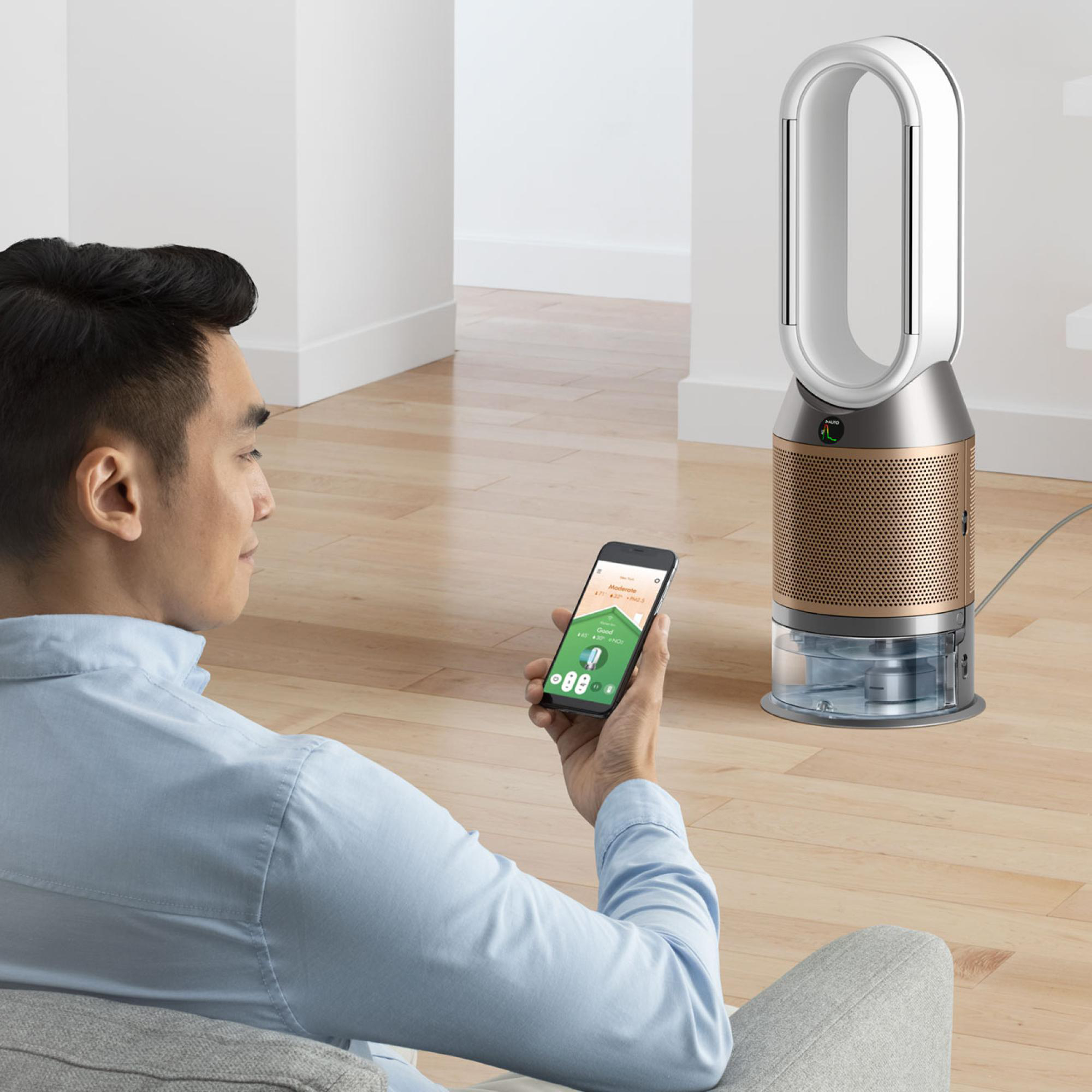Ein Mann, der ein Mobilgerät zur Steuerung eines Ventilators verwendet, der Ventilator im Hintergrund.