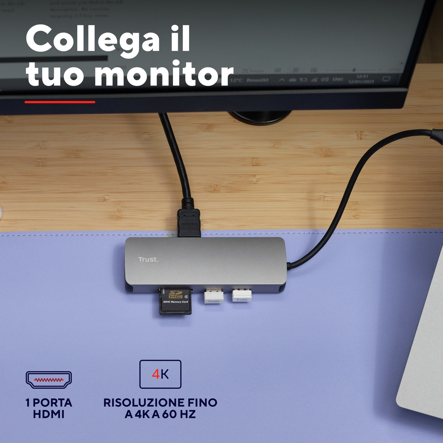 Un hub USB-C grigio collegato a un laptop. Ci sono porte per schede SD e USB.