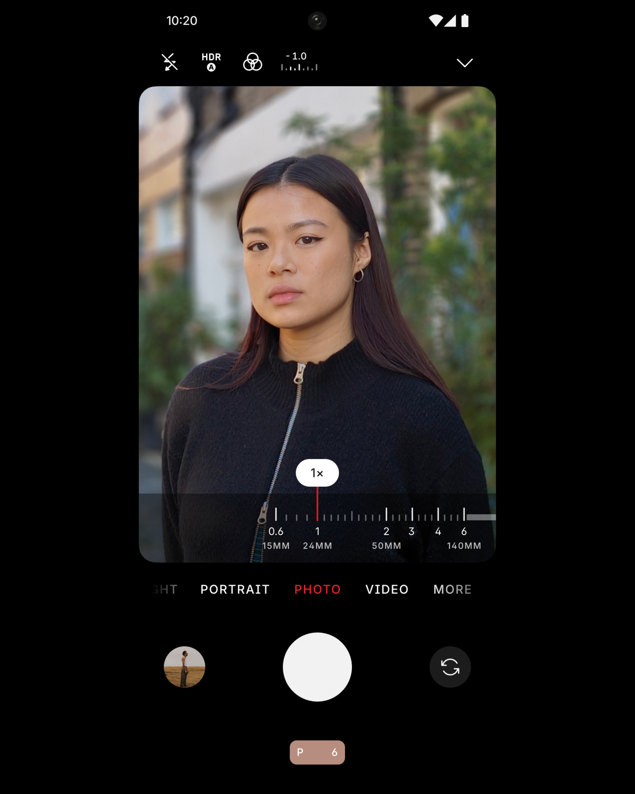 Eine Frau, die die Kamera auf ihrem Telefon betrachtet. Das Telefon zeigt die Kameraschnittstelle.