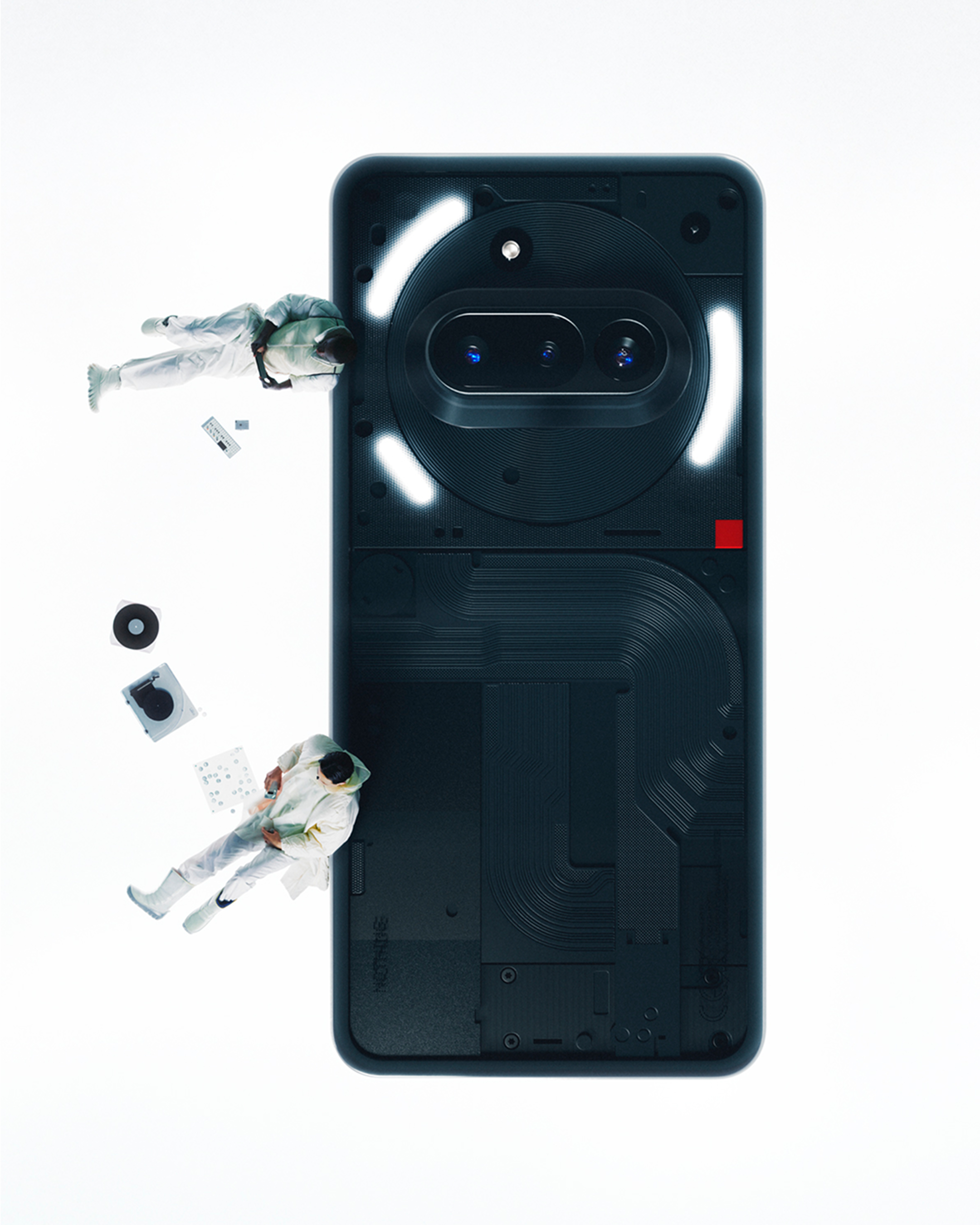 Nothing-Telefon mit transparentem Rücken, zwei Astronauten schweben, Objekte auf weißem Grund.