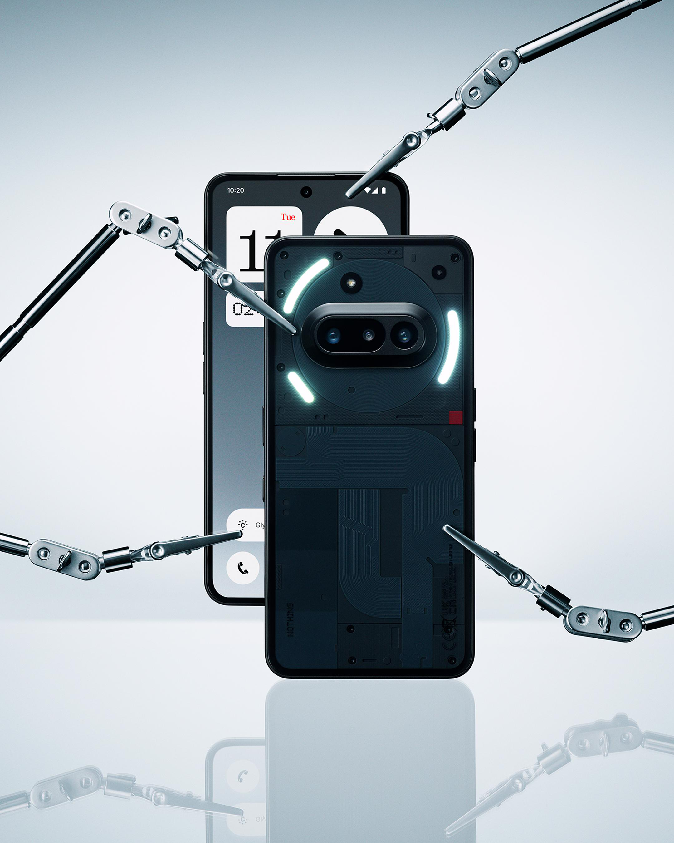 Zwei Nothing Phone (2) Telefone, eines mit eingeschaltetem Bildschirm. Mechanische Arme um die Telefone.