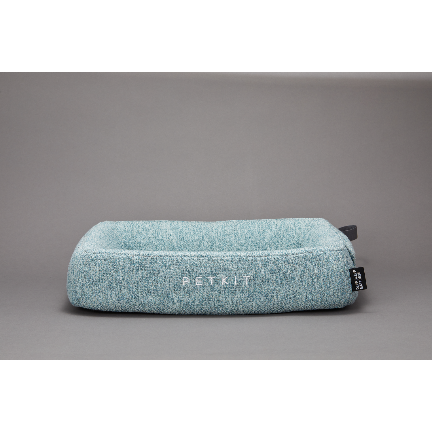 A light blue pet bed with PETKIT written on it, a gray tag on the side, and a gray background.