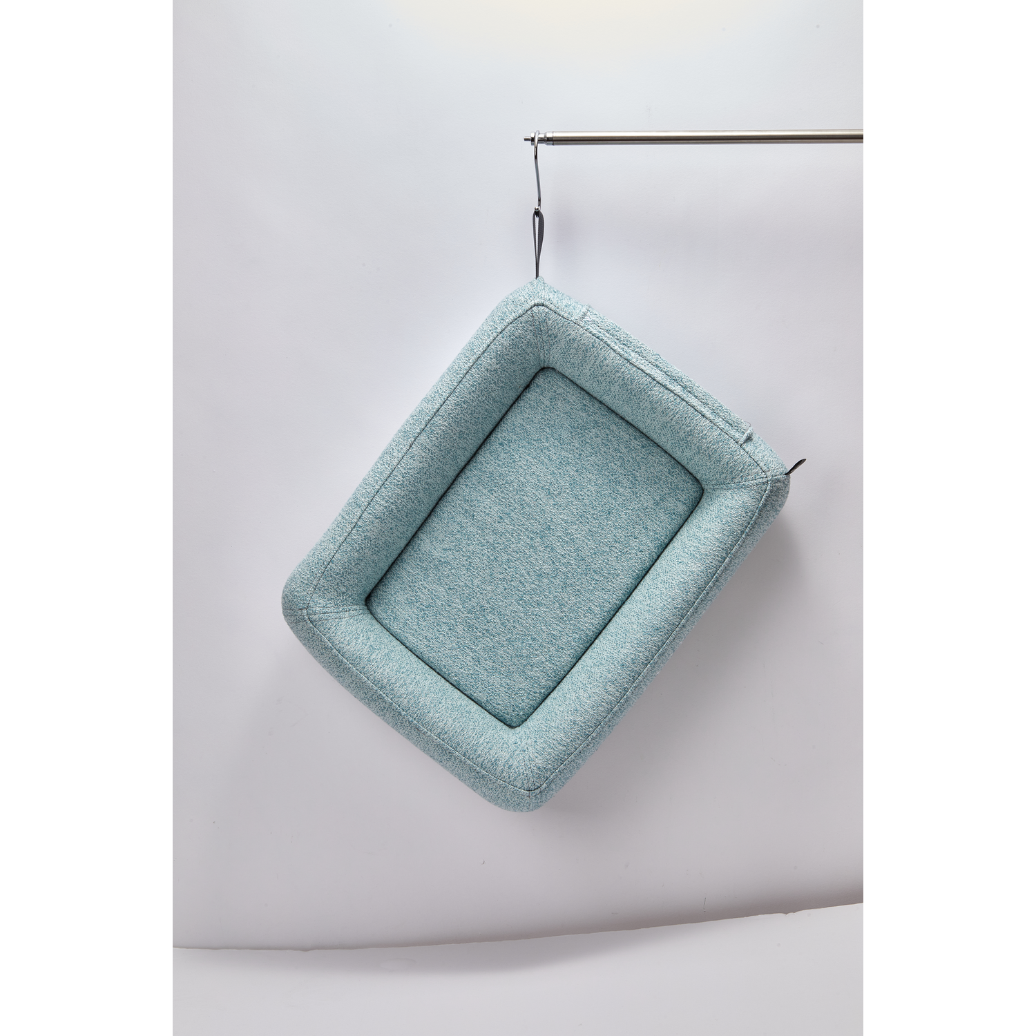 A hanging pet bed, turquoise color, rectangular shape, on a white background.