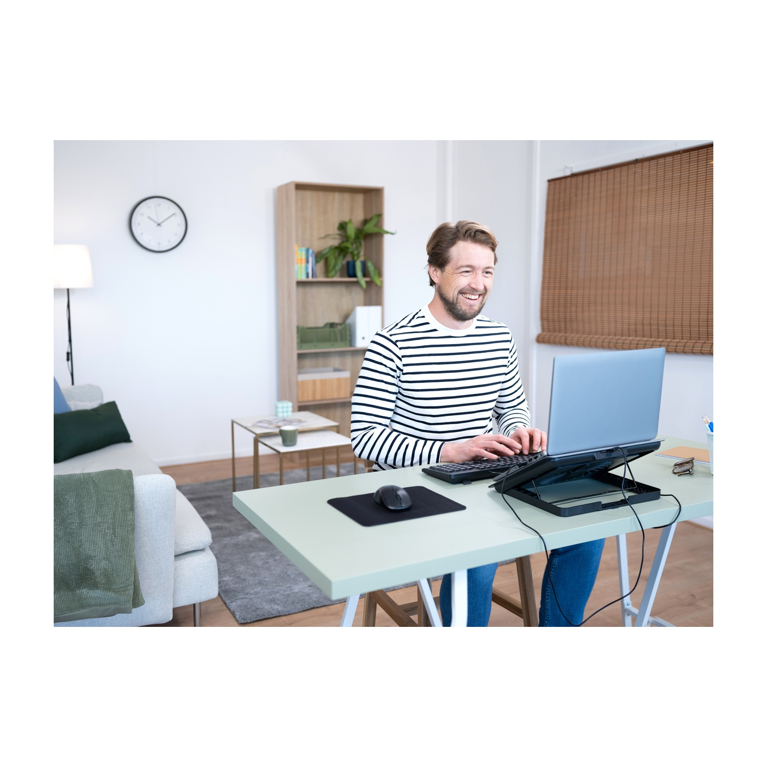 Uomo che lavora su un laptop a una scrivania in un ambiente di home office.