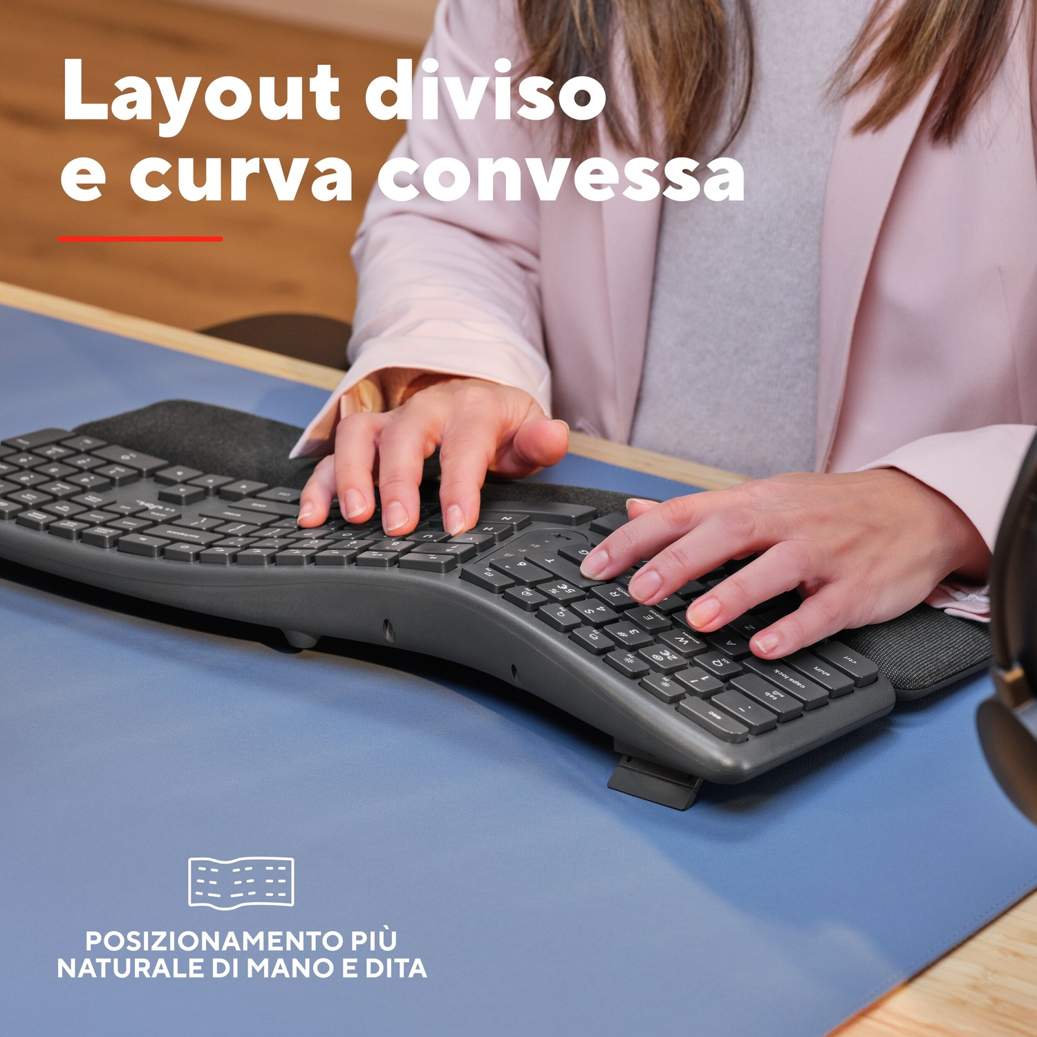 Mani che digitano su una tastiera ergonomica su superficie blu, overlay di testo.