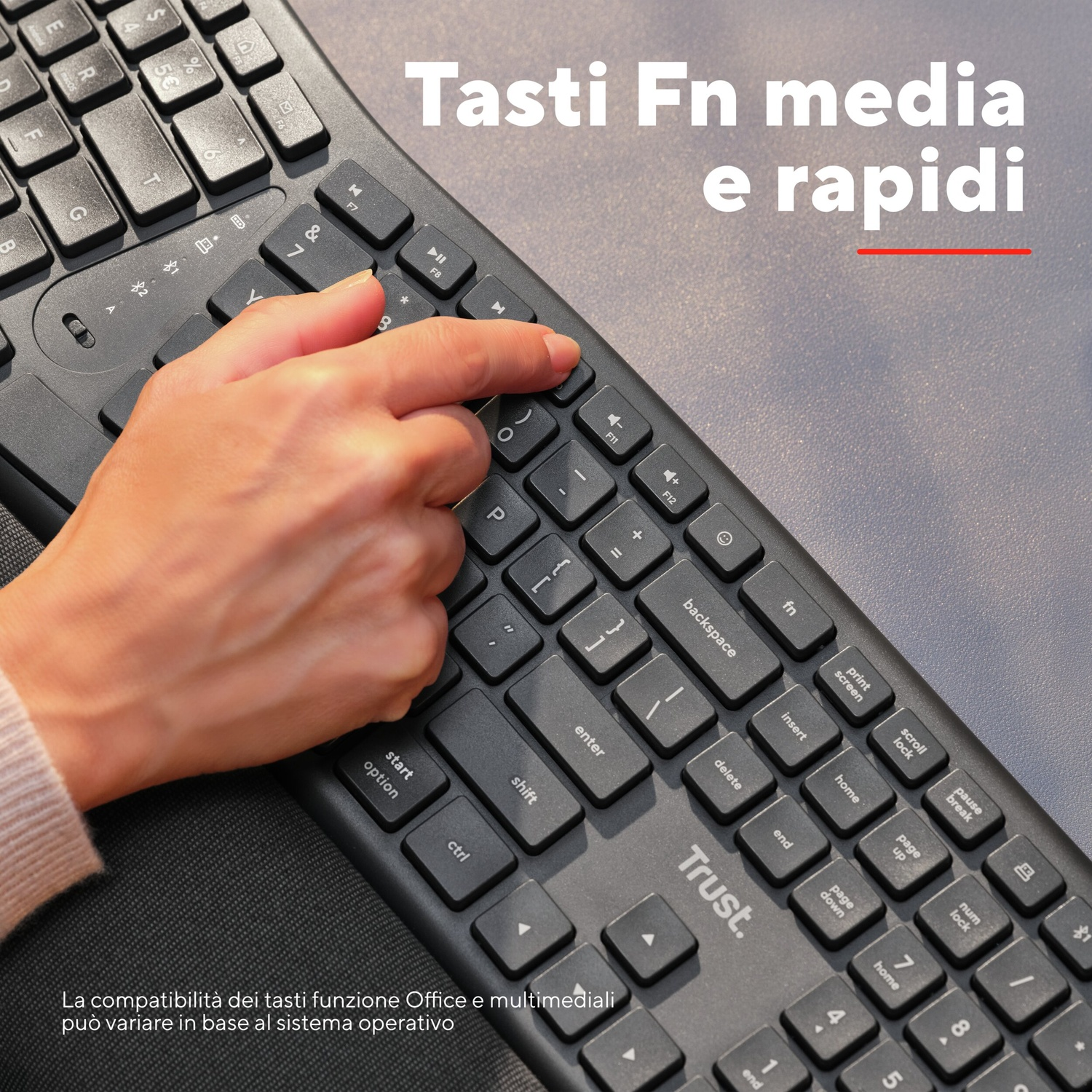Una mano che preme un tasto su una tastiera nera. Testo in italiano.