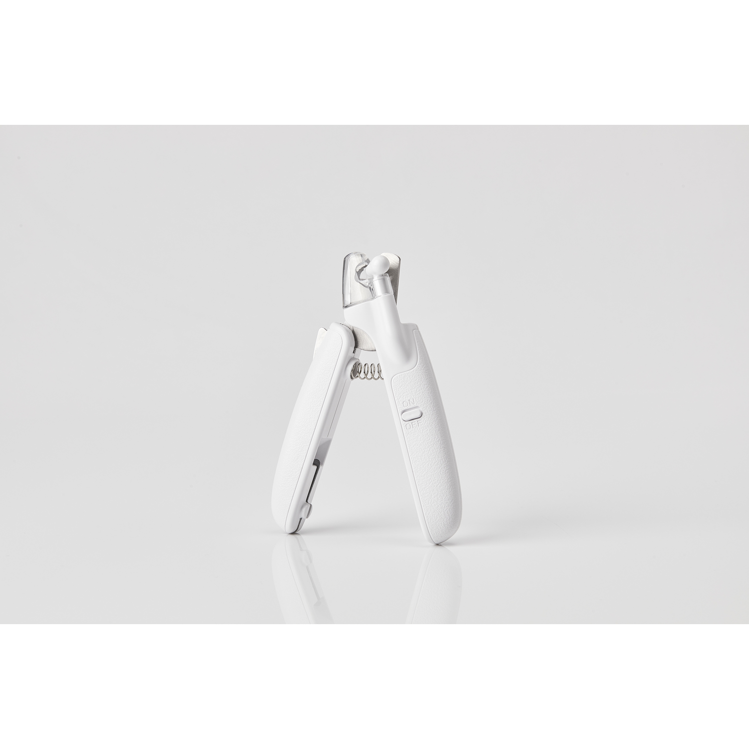 Witte nagelknipper voor huisdieren op wit oppervlak. Klauwen zichtbaar. Veer en handvatten ook zichtbaar.