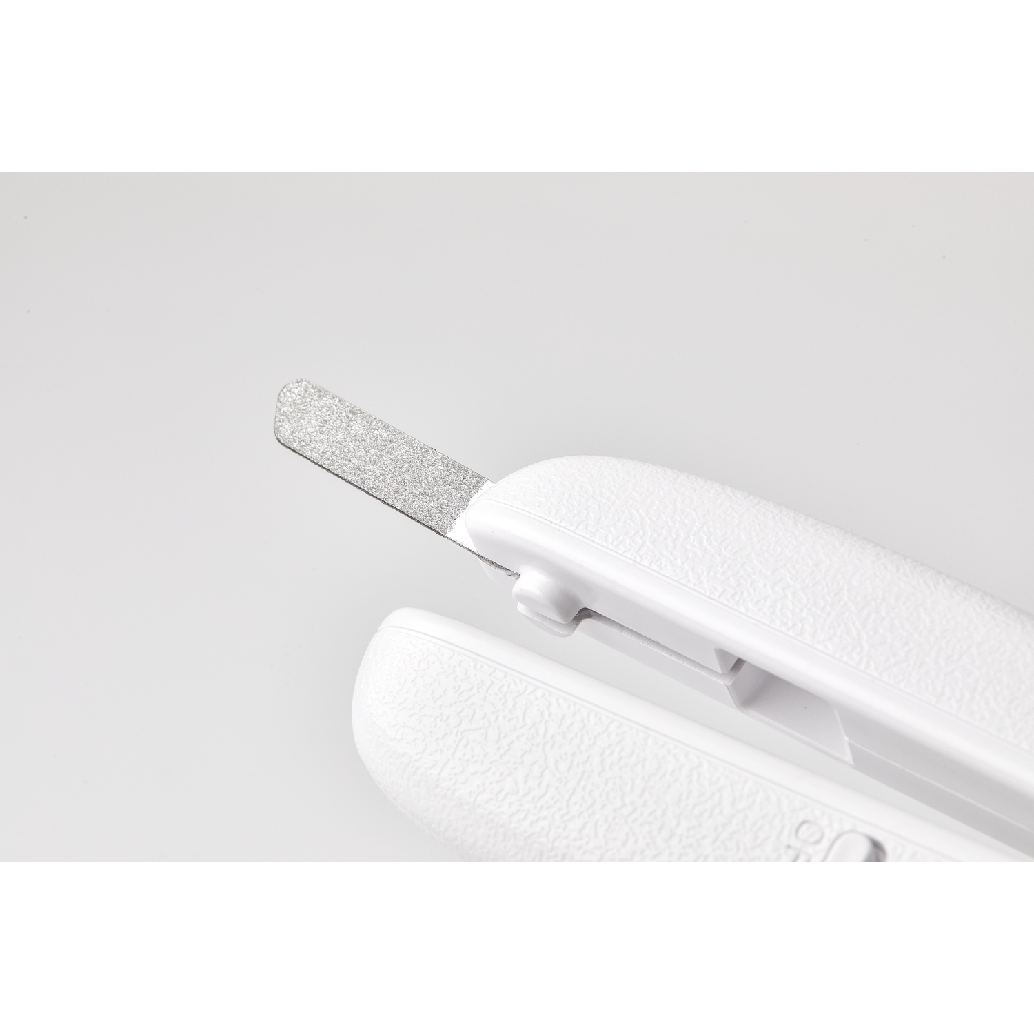 White nail clipper with a silver file. It is on a white background.