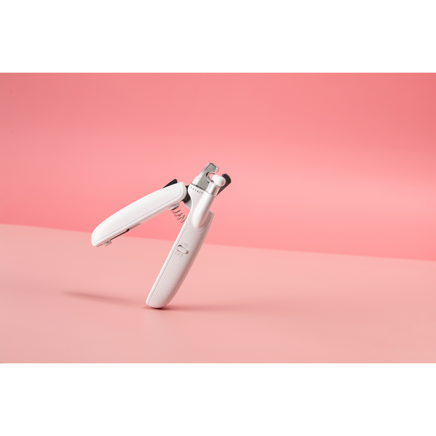 Nagelknipper voor huisdieren op een roze achtergrond. De knippers zijn wit. De achtergrond is roze.