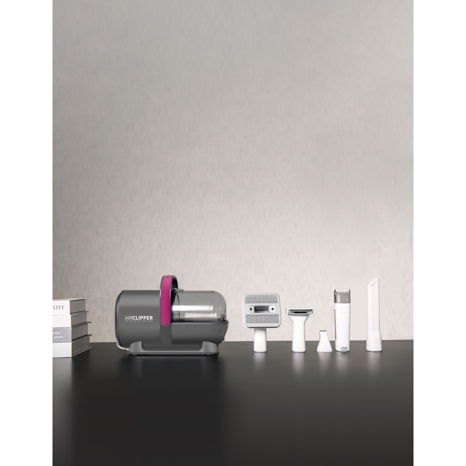 An Airclipper and accessories are arranged on a black table against a neutral wall.