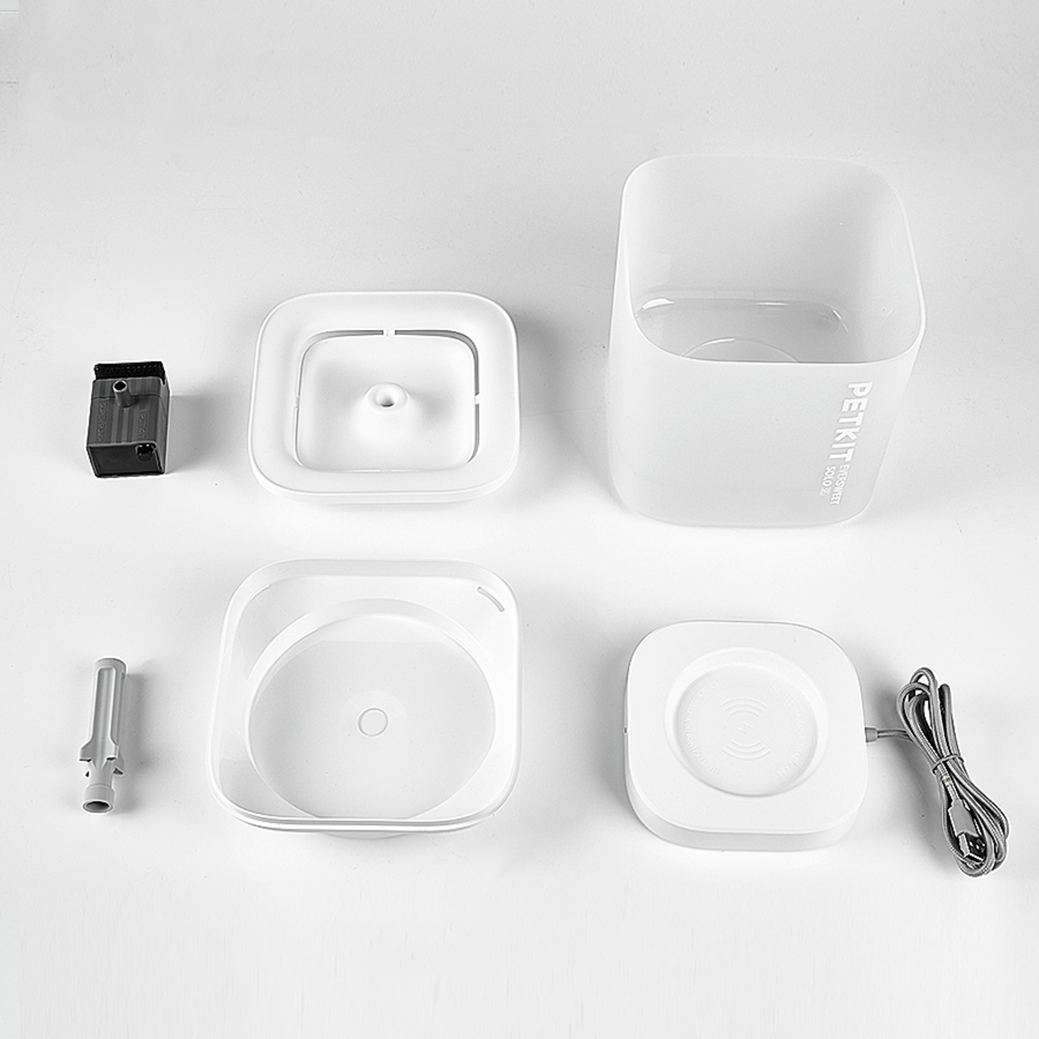 White pet water fountain parts, including a square container and a pump.