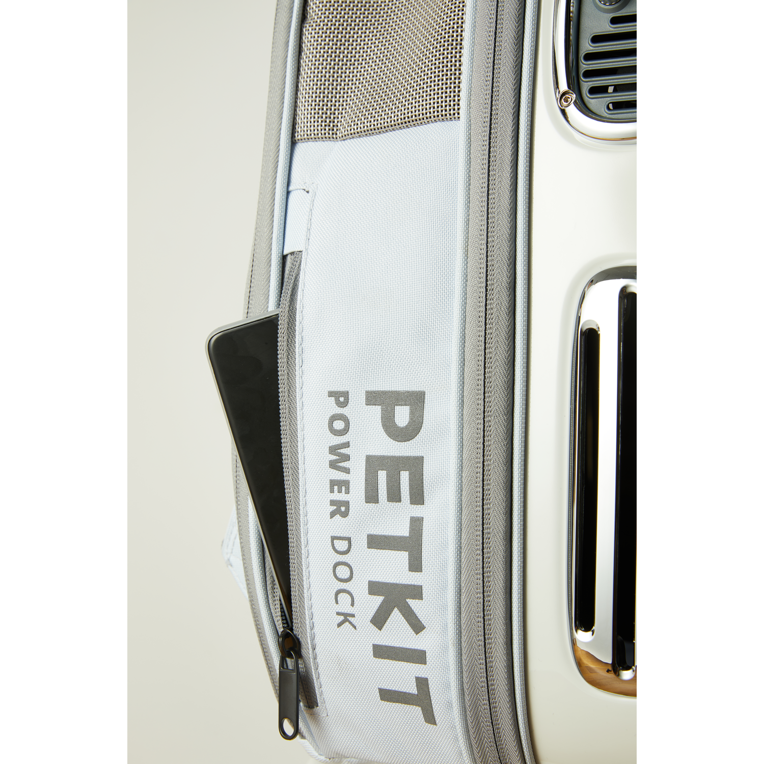 A close-up of a light blue PETKIT Power Dock bag with a phone in a pocket.