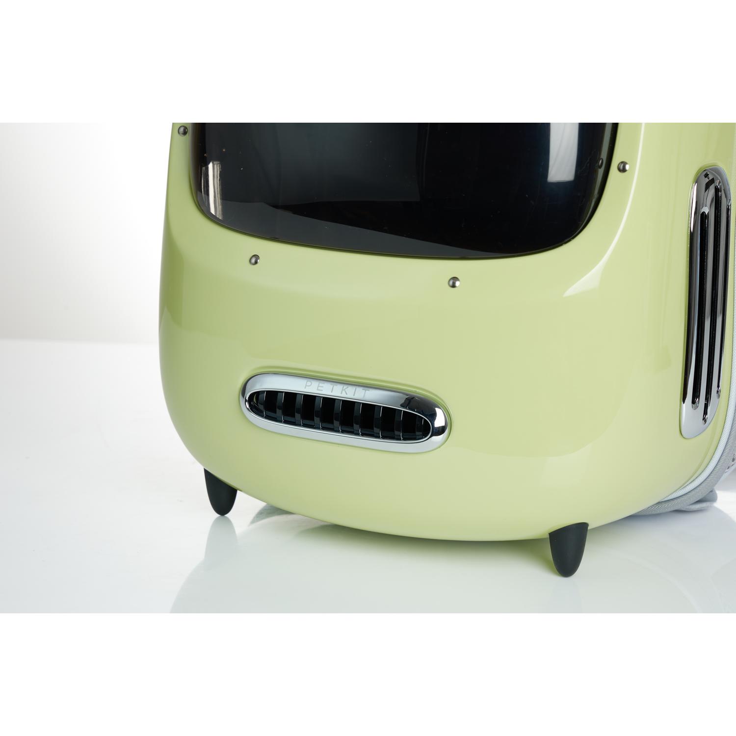 Close-up of a pet carrier in a light green color. The front has a vent and a PETKIT logo.