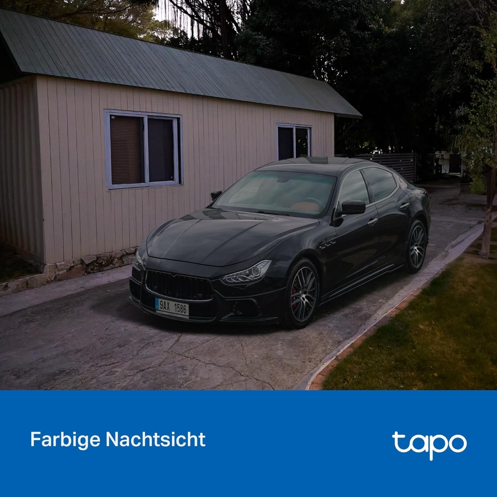 Ein schwarzer Maserati vor einem beigen Haus mit Tapo-Logo geparkt.