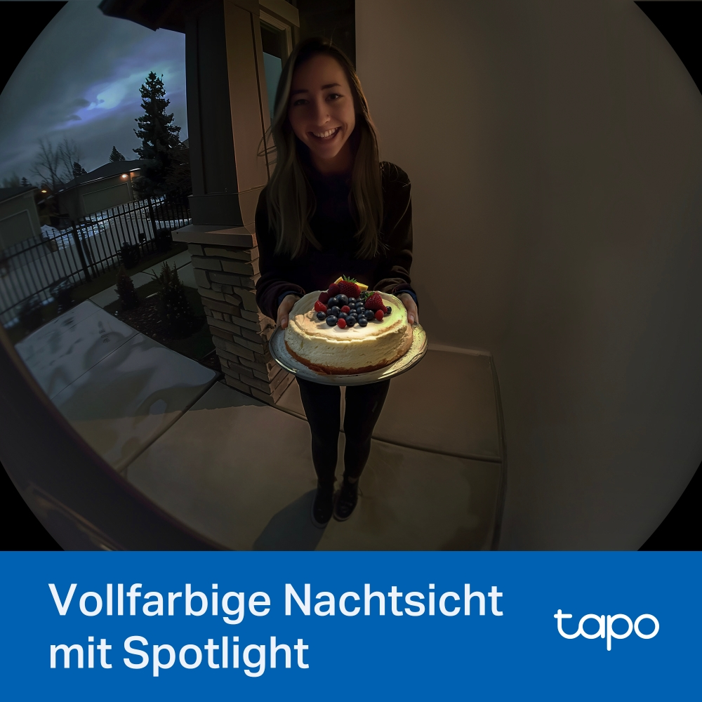 Frau hält Kuchen bei Nacht. Kamera ist vor der Tür positioniert.