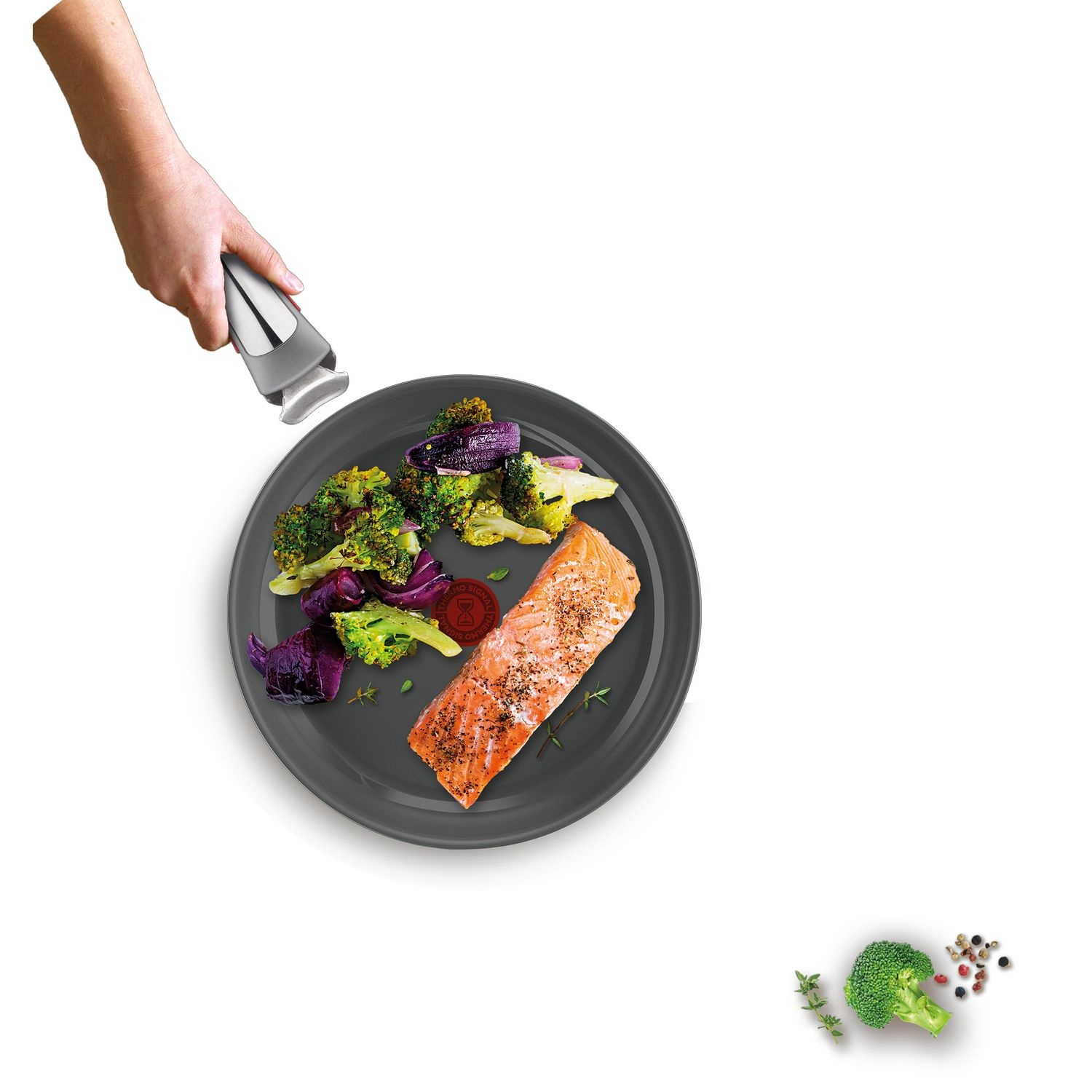 Une assiette avec du saumon, du brocoli et du chou rouge, avec une main tenant un ustensile.