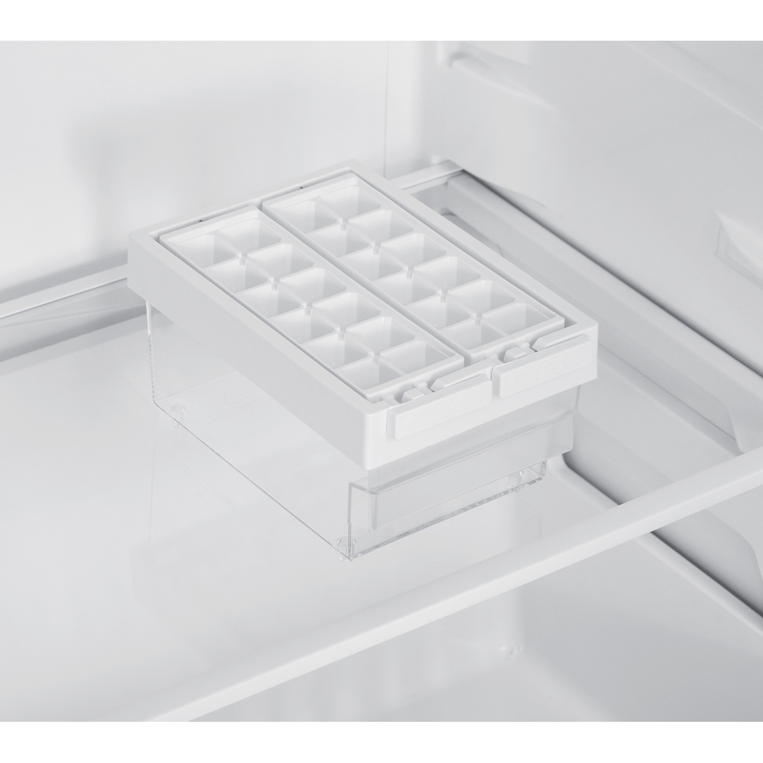 An open refrigerator with two ice cube trays, inside, on a white surface.