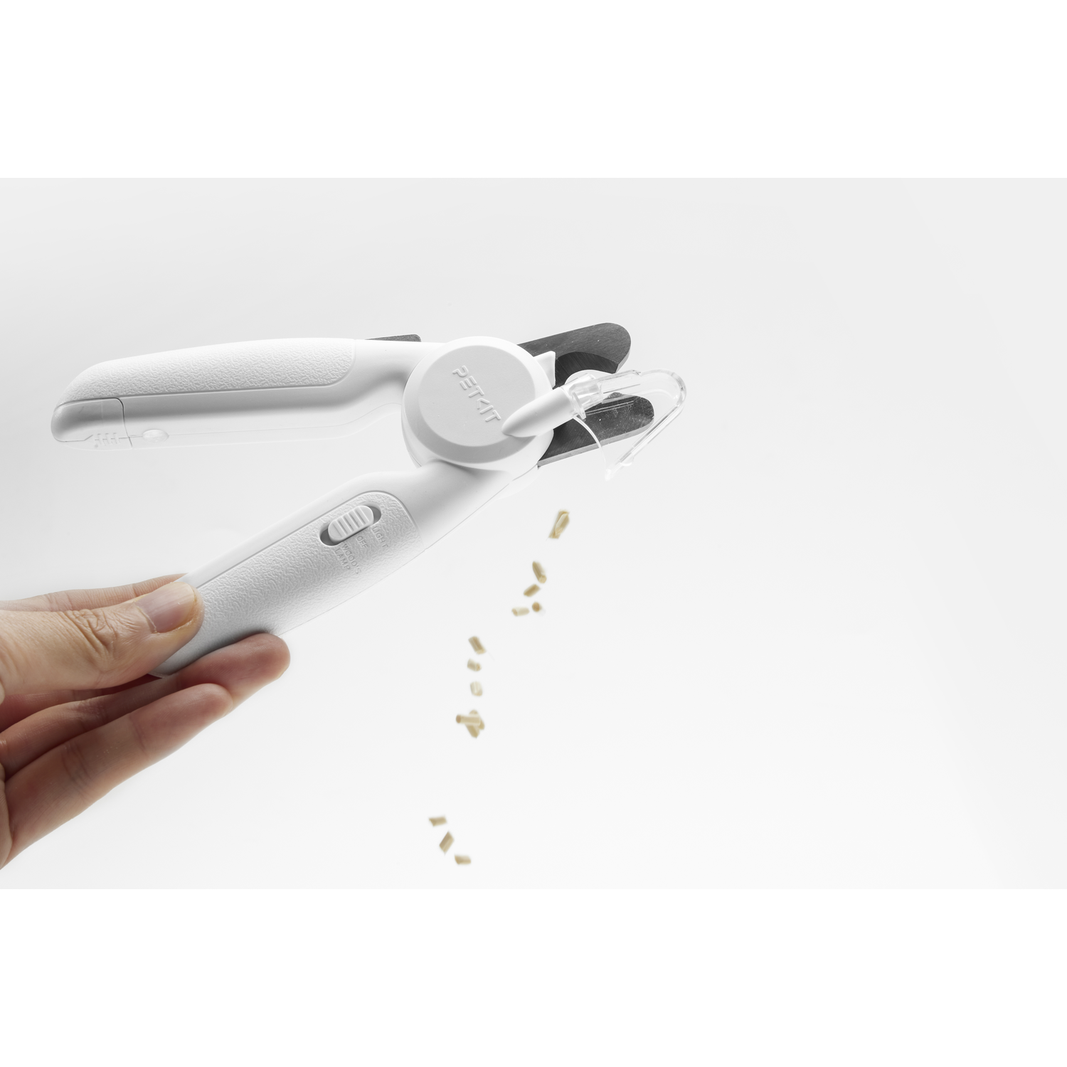 A white pet nail clipper with nails being cut.