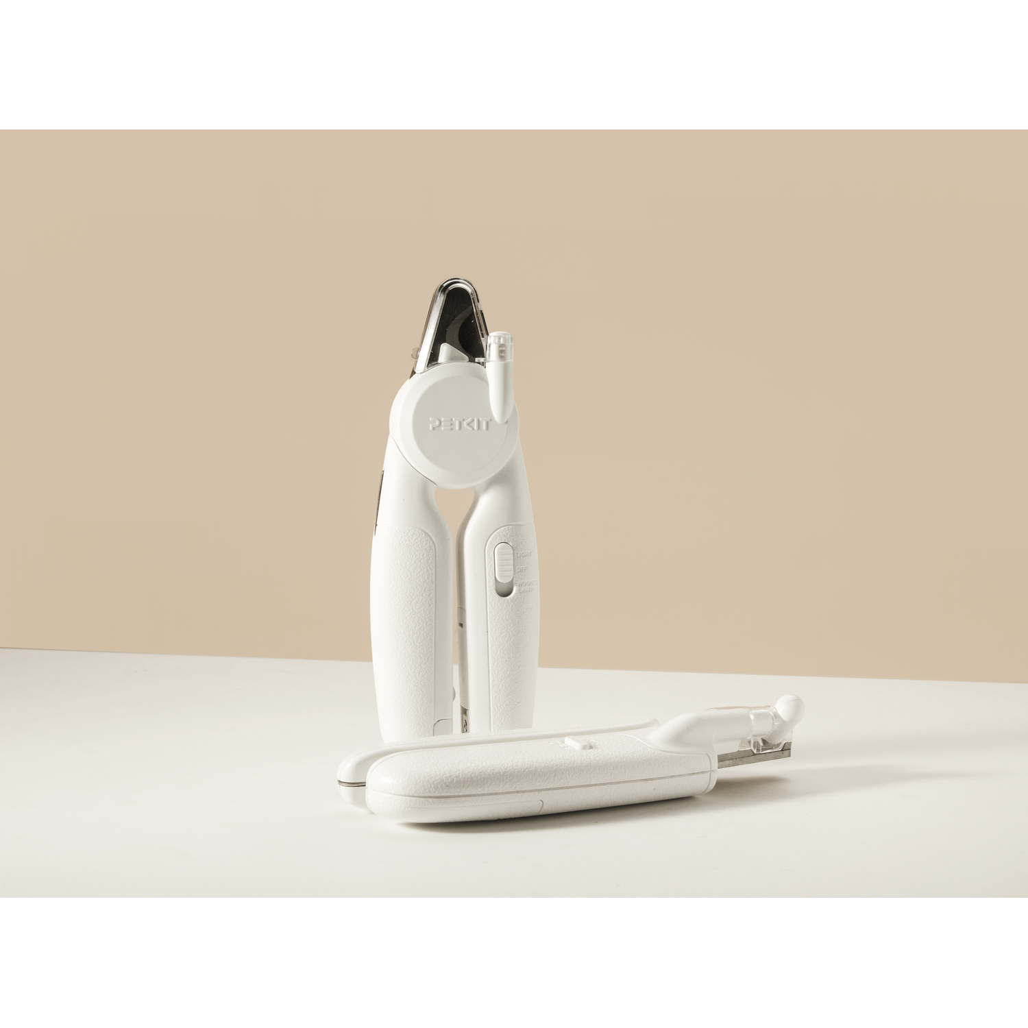Two white pet nail clippers on a neutral background.