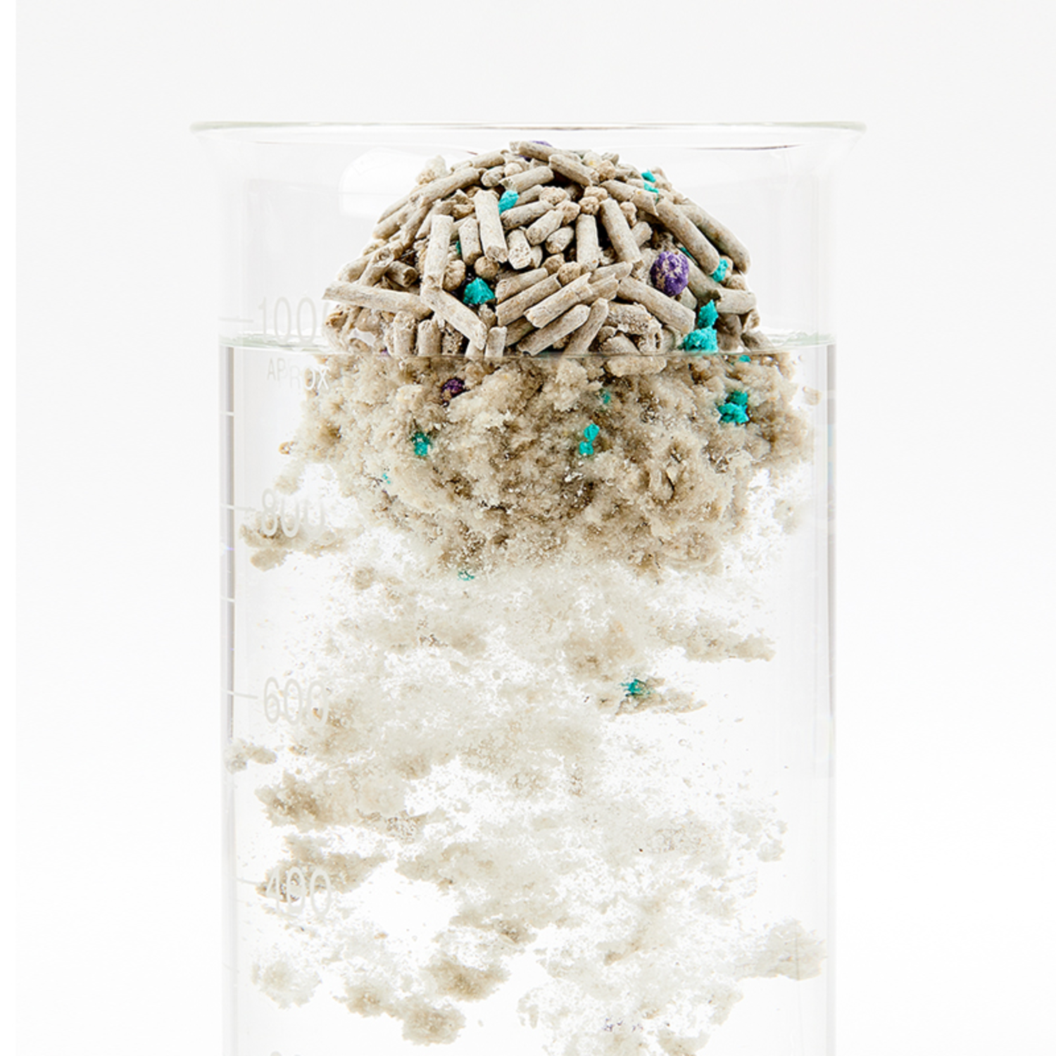 A clear beaker with a layered structure of cat litter and water.