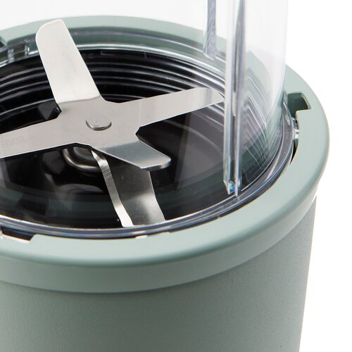 Zbliżenie na ostrza blendera wewnątrz zielonego kubka blendera, widok z góry.