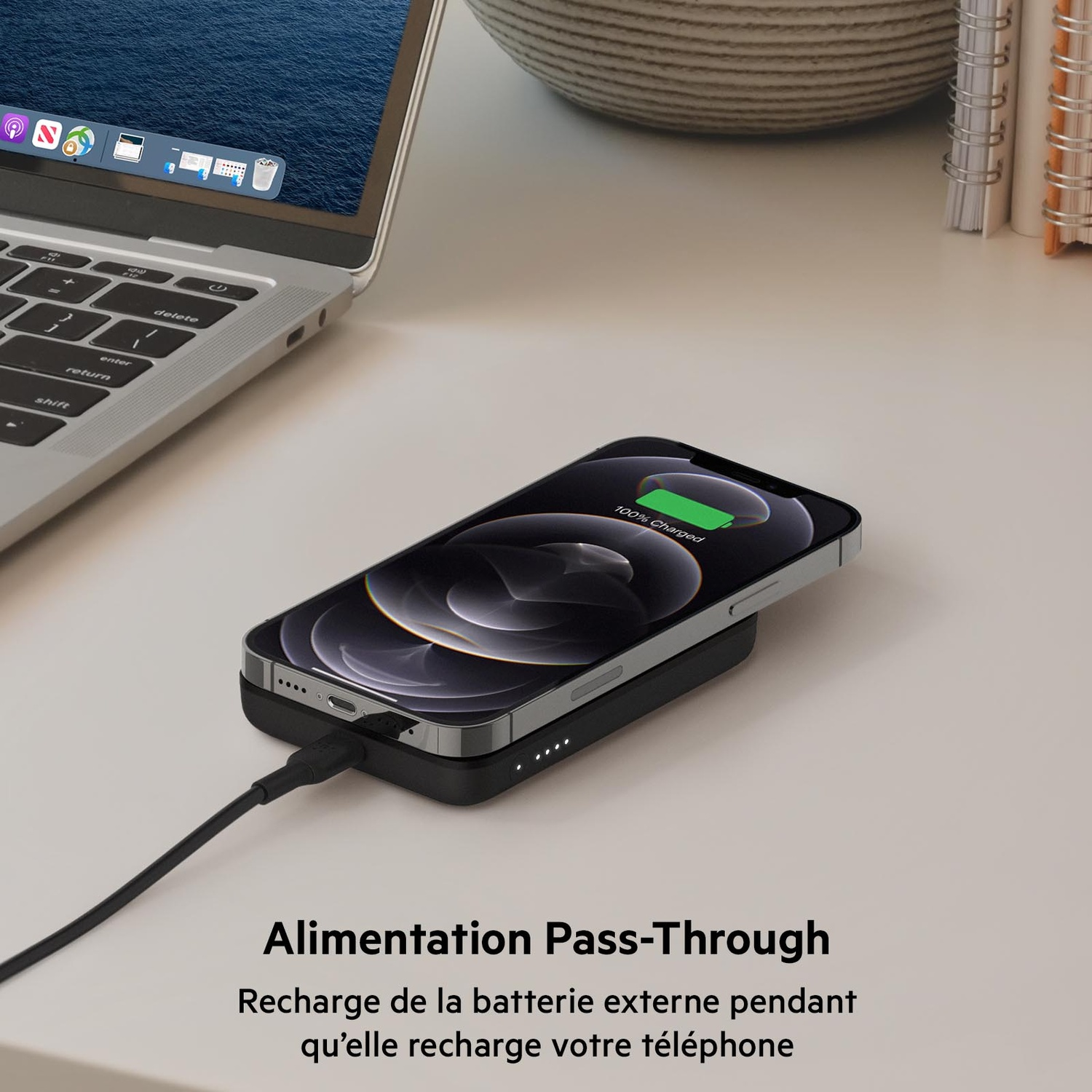 Téléphone en charge sur un pad noir, connecté à un ordinateur, texte: Power Pass-Through.