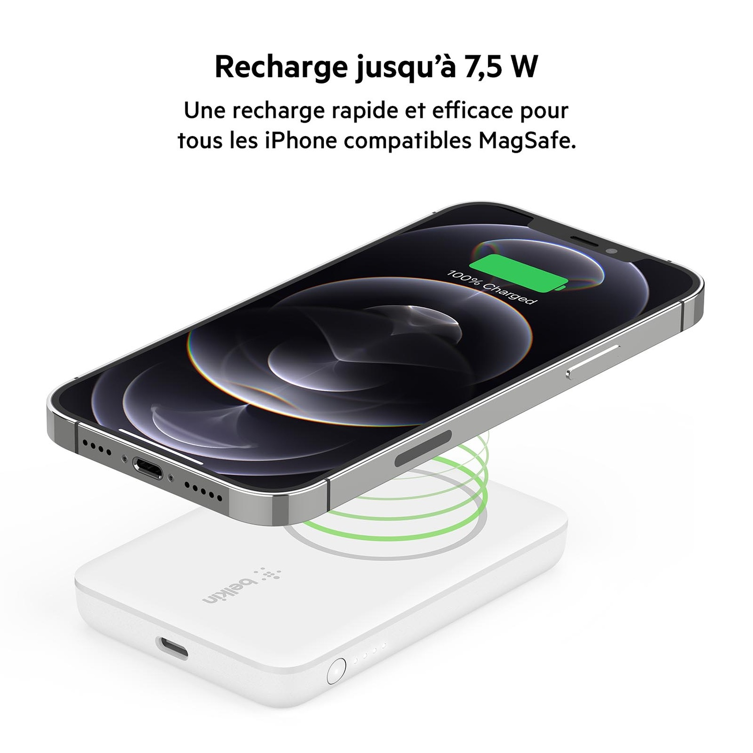iPhone en charge sur un chargeur sans fil blanc. Affiche 100% chargé, fond blanc.