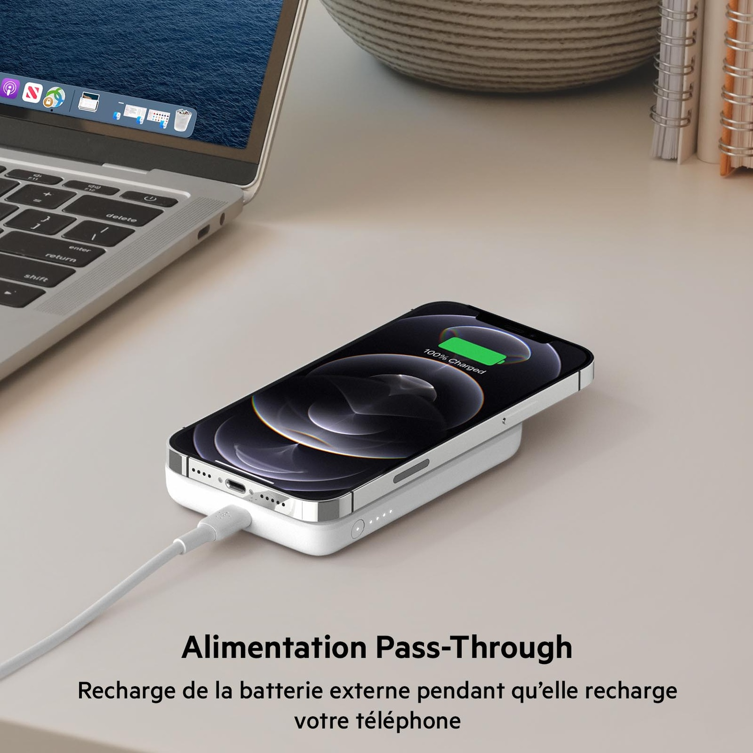 iPhone en charge sur un socle blanc à côté d'un ordinateur portable. Texte : 'Power Pass-Through'.