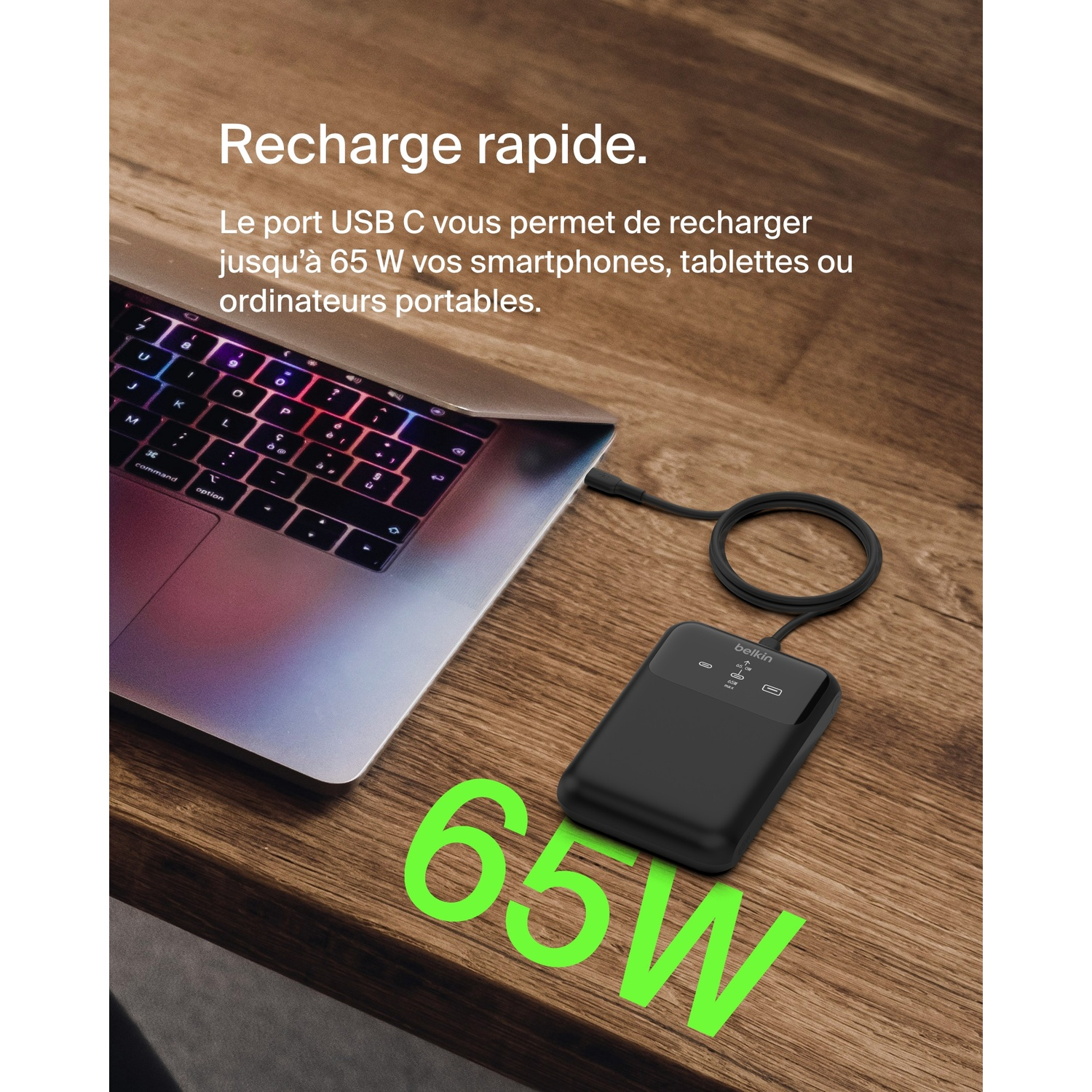 Chargeur portable noir connecté à un ordinateur portable. Le chargeur affiche '65W' en vert.