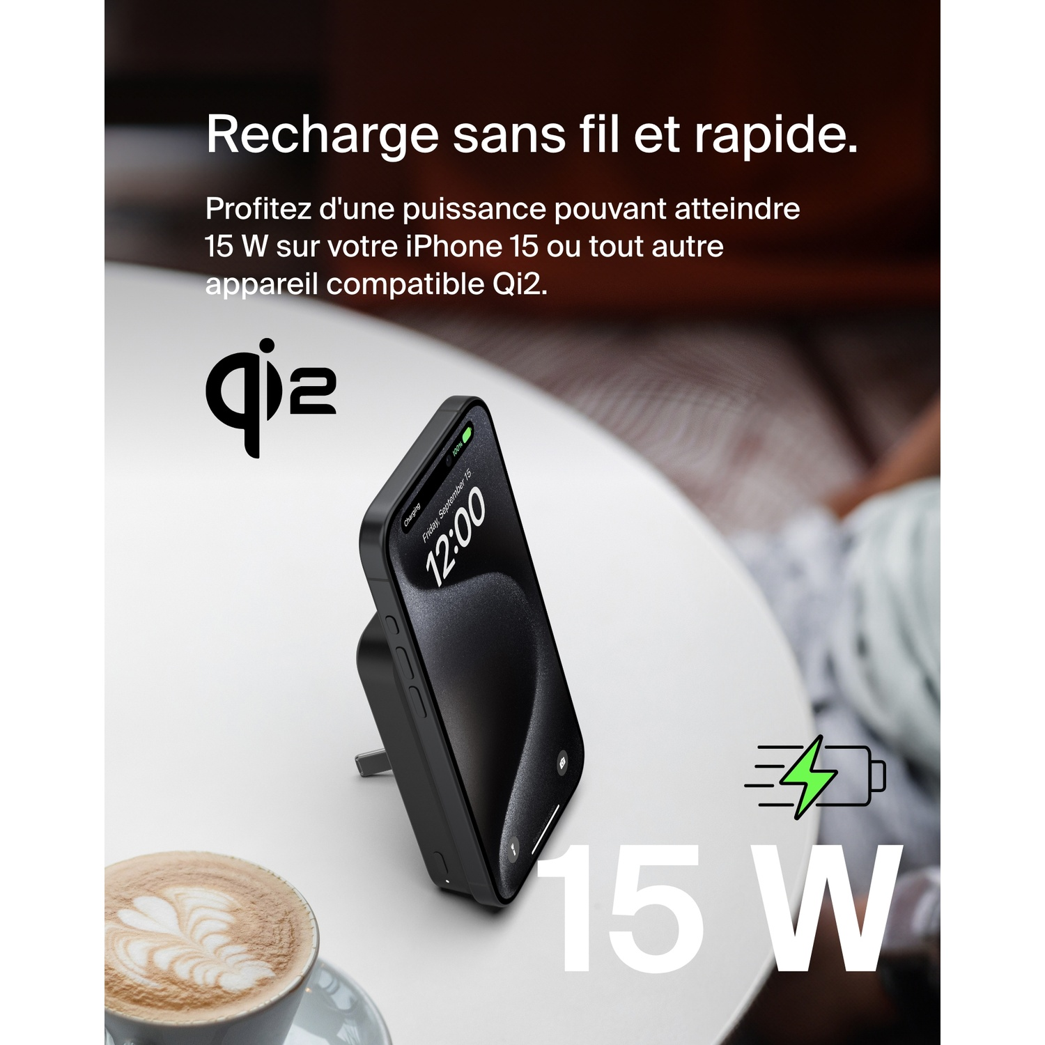 Un téléphone se chargeant sur un chargeur sans fil à côté d'une tasse de café.