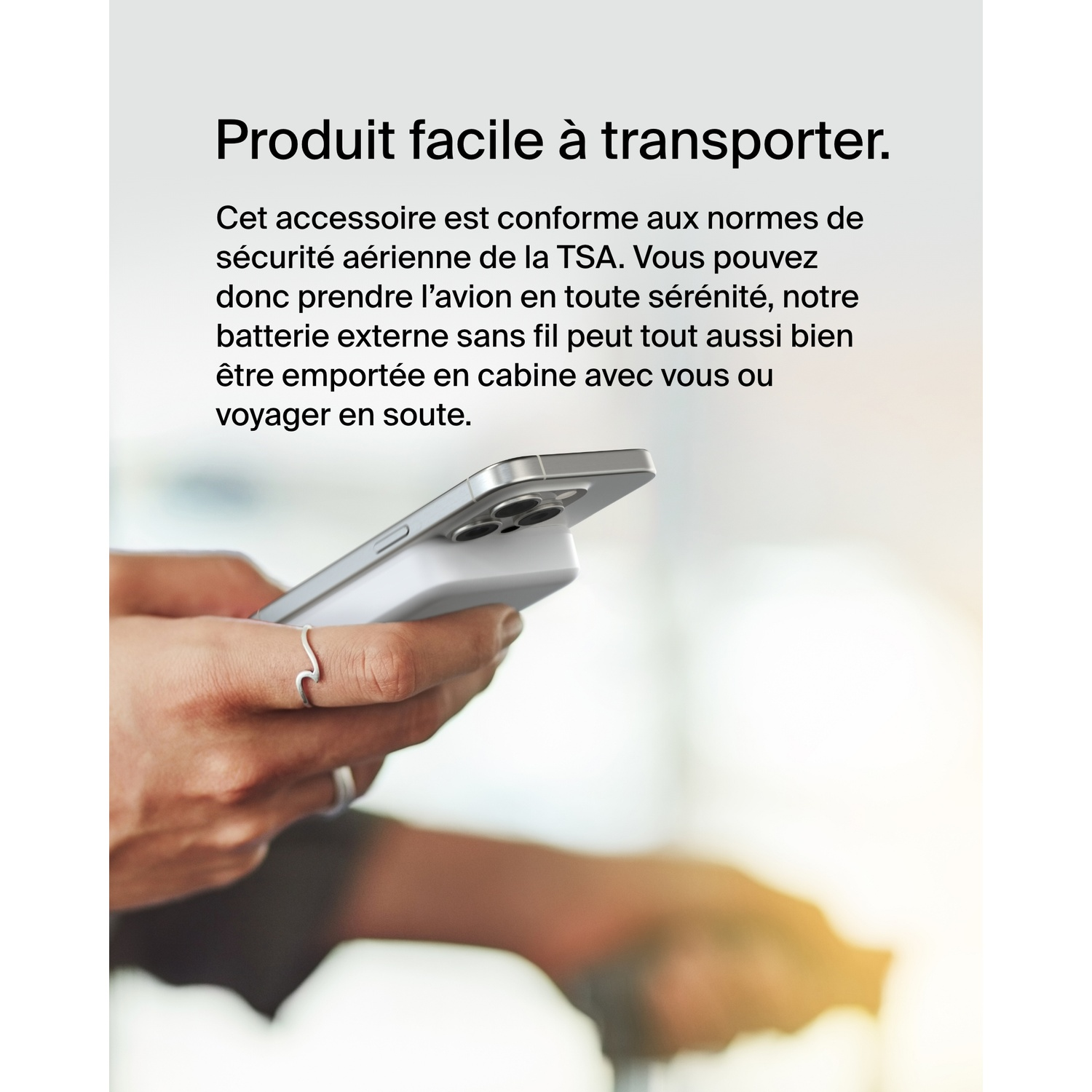 Une main tenant un téléphone attaché à une batterie externe blanche, texte sur la sécurité.