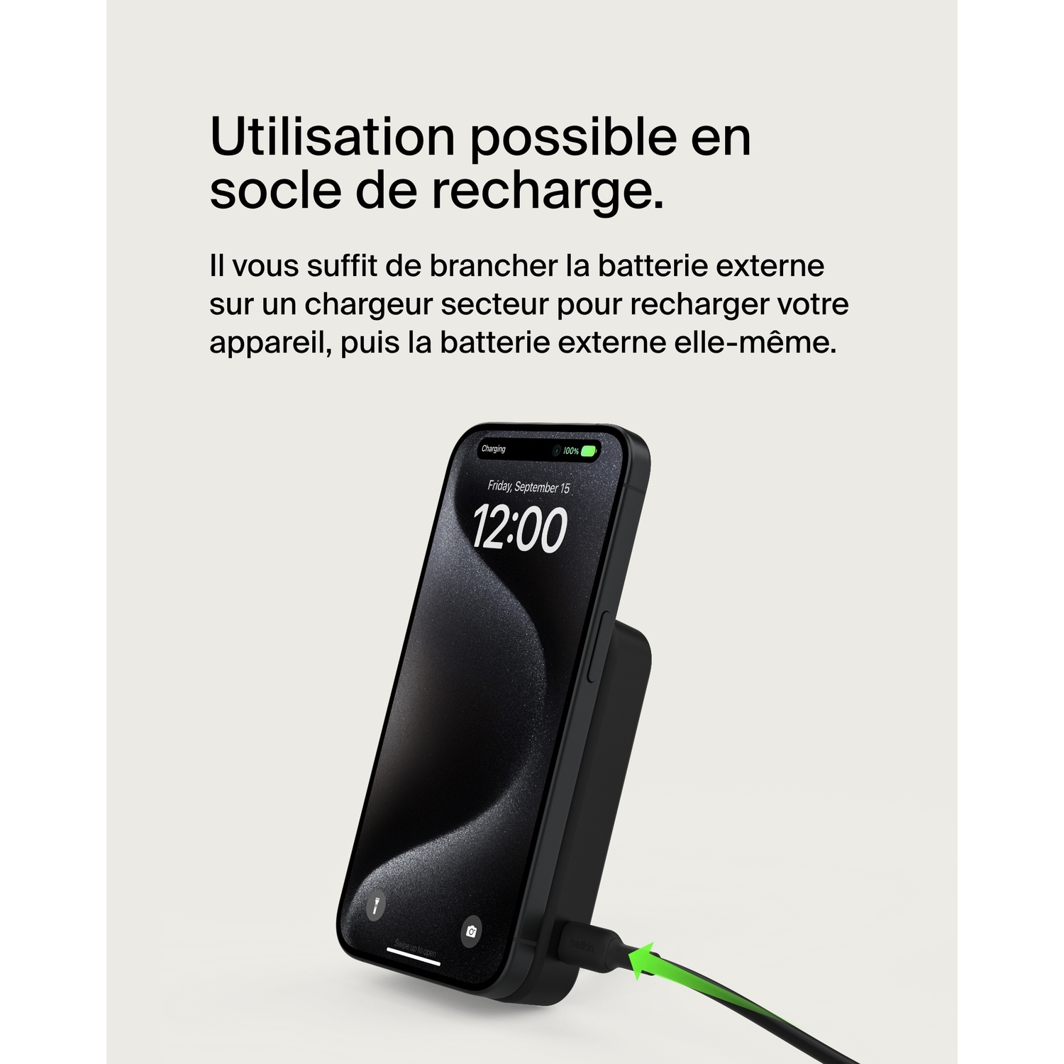 Un téléphone noir se charge sur un socle noir. L'écran affiche l'heure et la date.