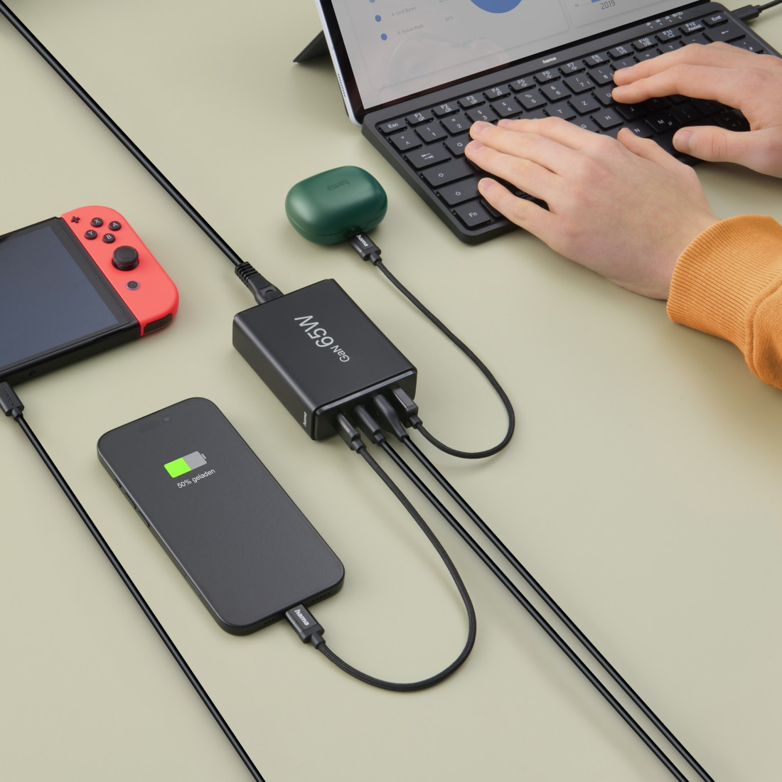 Eine schwarze Ladestation mit mehreren Geräten, darunter ein Telefon und eine Spielkonsole.
