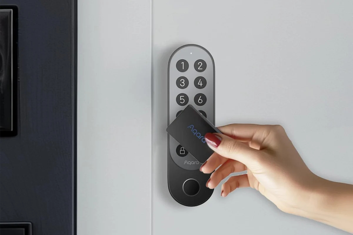 Osoba wkłada kartę klucza do inteligentnego zamka. Zamek ma klawiaturę numeryczną i logo Aqara.