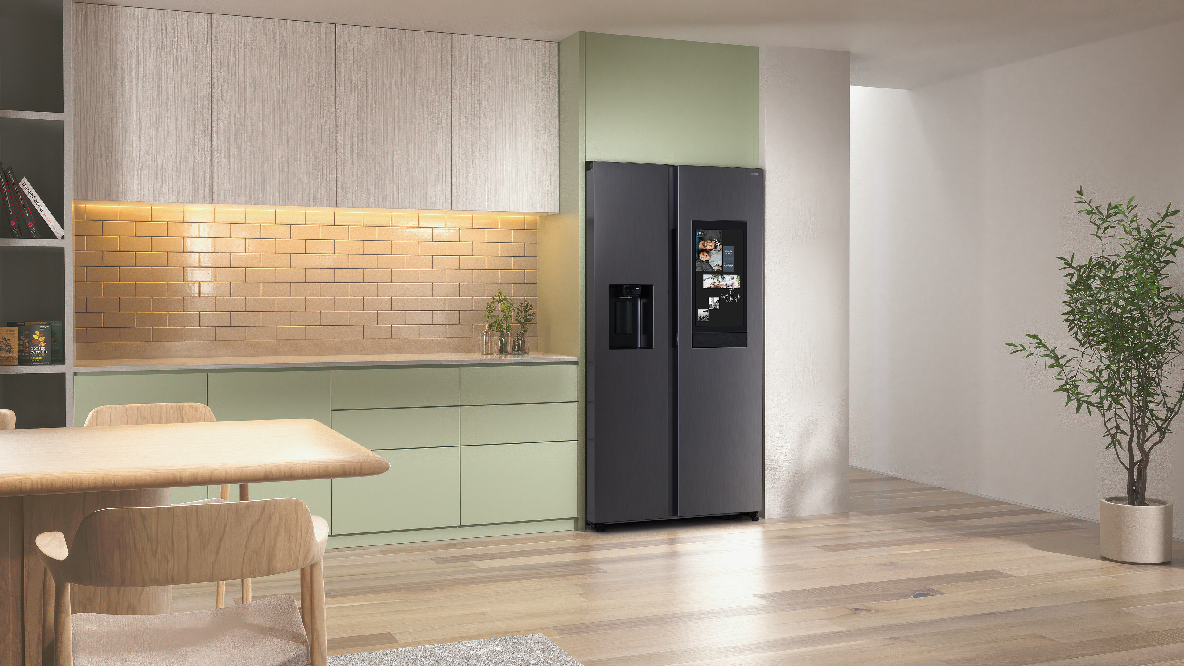 Eine moderne Küche mit einem schwarzen Kühlschrank. Es gibt einen Holztisch, eine Pflanze und eine helle Wand.
