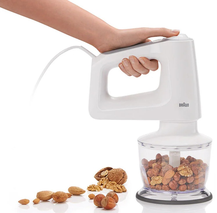 Biały blender ręczny z orzechami w przezroczystym pojemniku. Orzechy poniżej. Marka Braun.