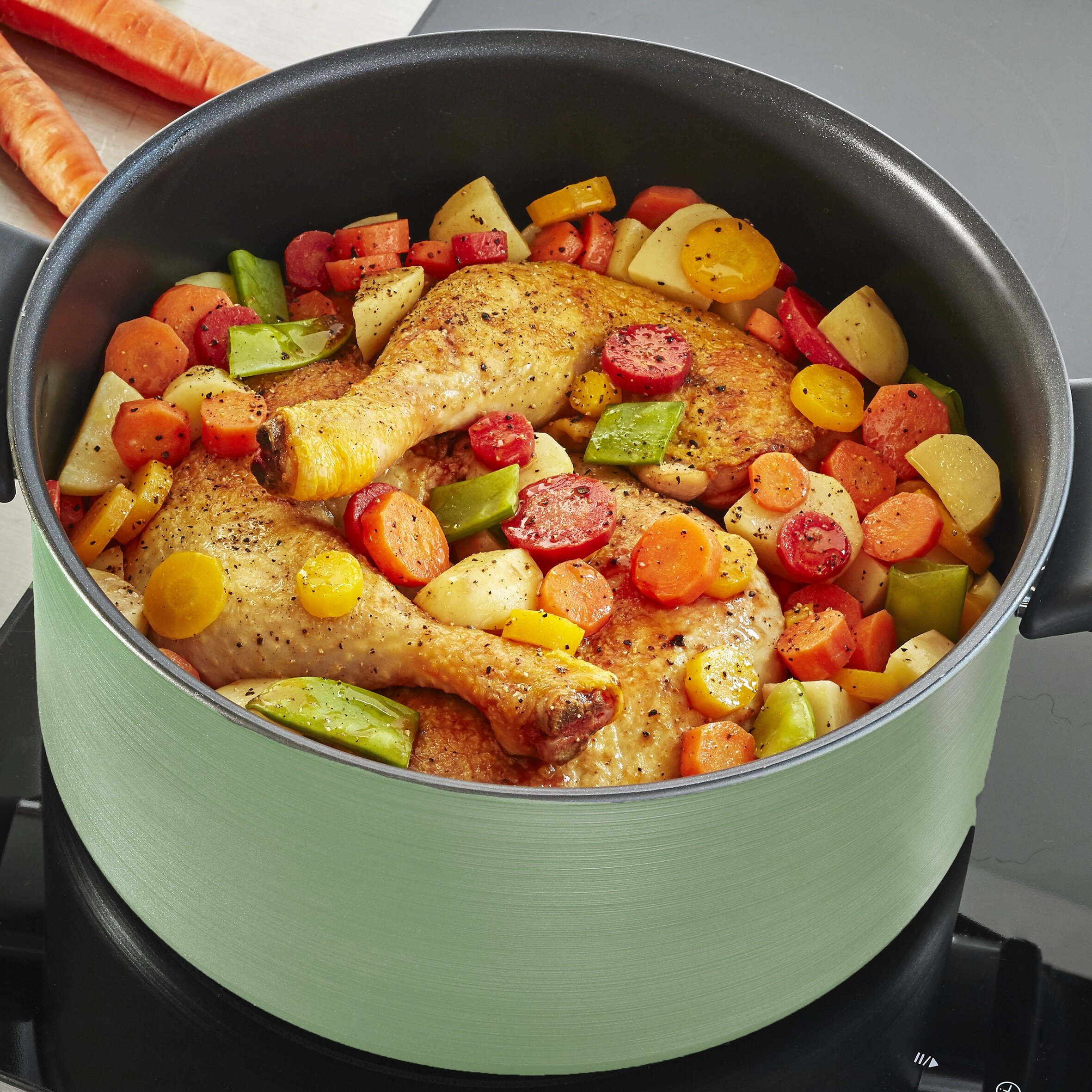 Kurczak w zielonym garnku z różnymi warzywami, gotowany na kuchence, ujęcie z bliska.