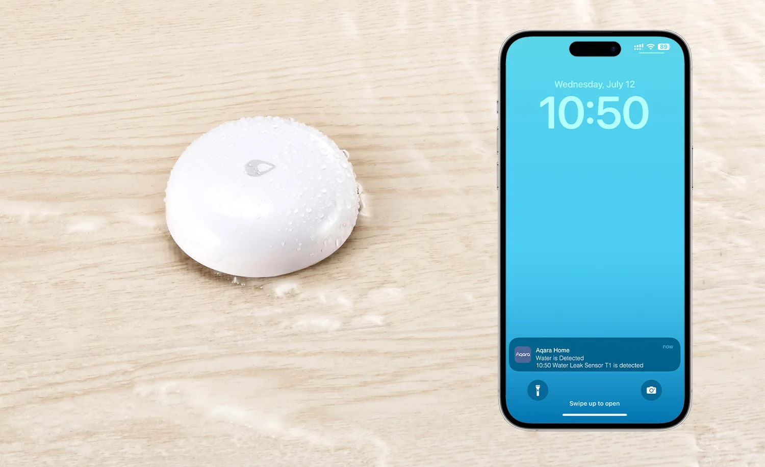 Biały czujnik wody z kroplami wody obok telefonu wyświetlającego powiadomienie o wykryciu wody.