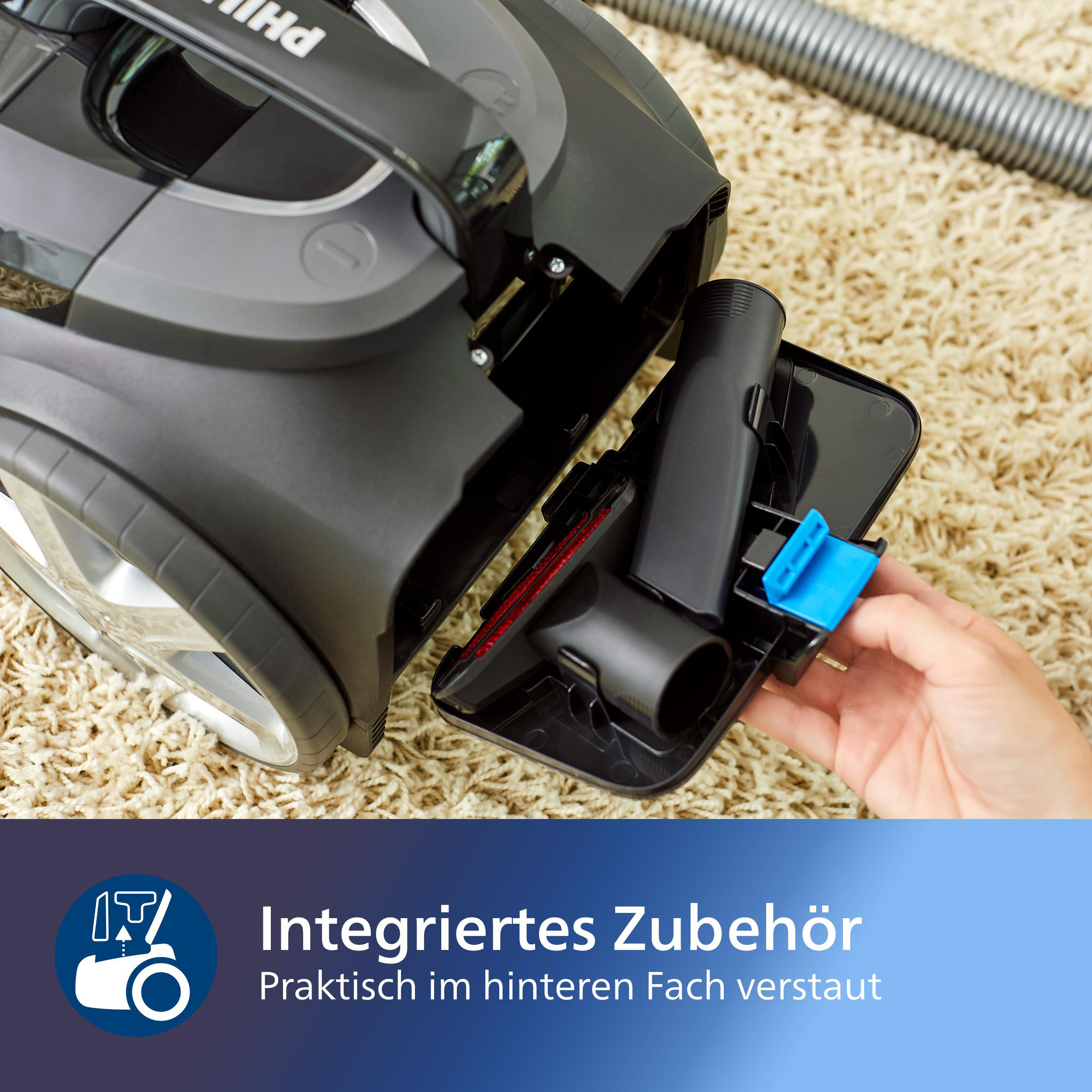 Staubsauger mit integriertem Zubehör. Eine Hand zieht eine Bürste aus der Rückseite.